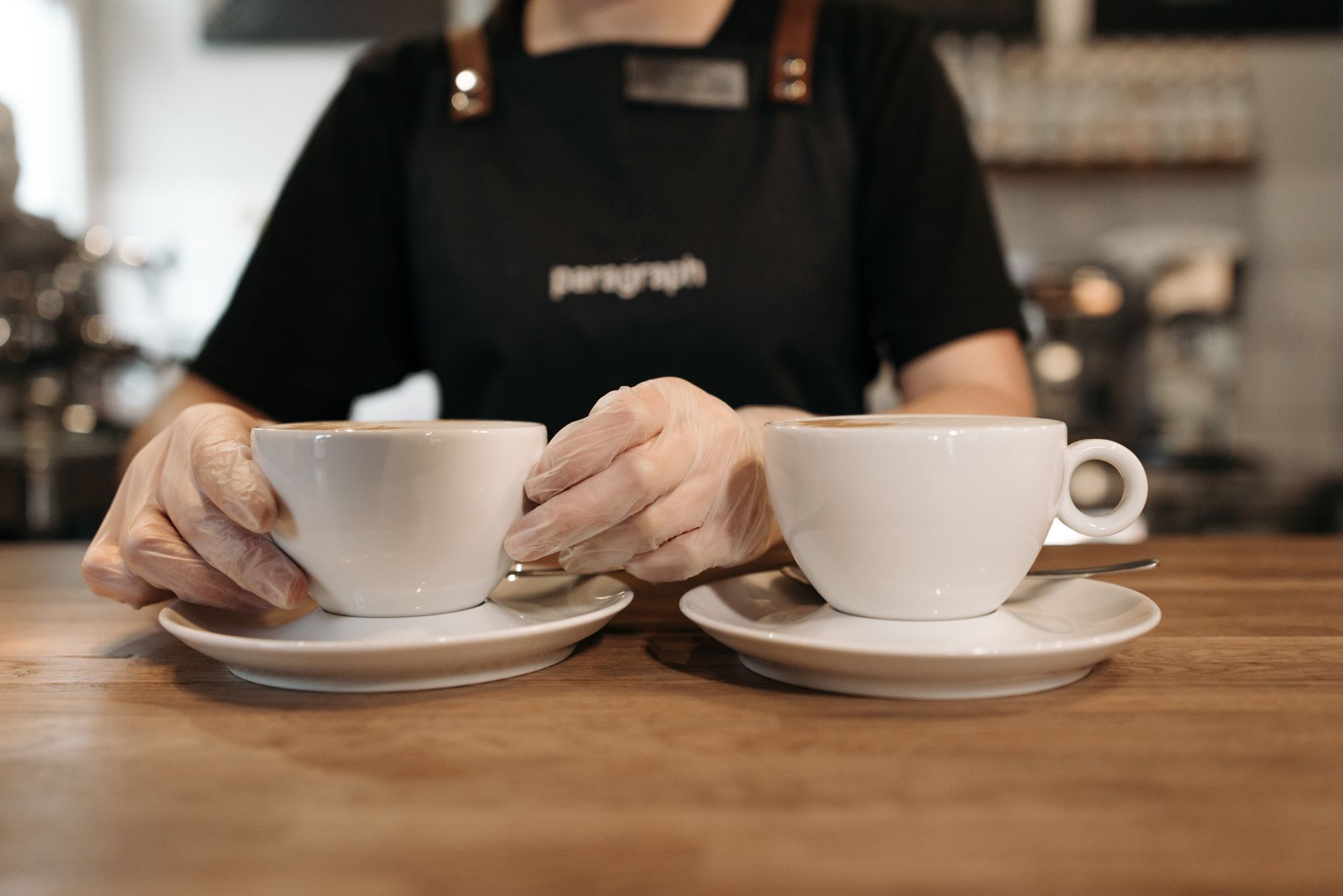 Barista serving coffee in a café, highlighting café culture and customer service.