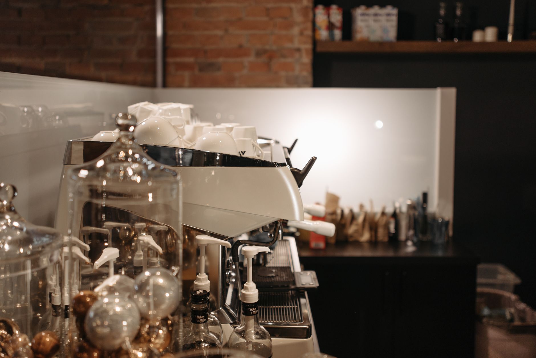 A cozy coffee shop interior featuring a modern espresso machine and various coffee accessories.