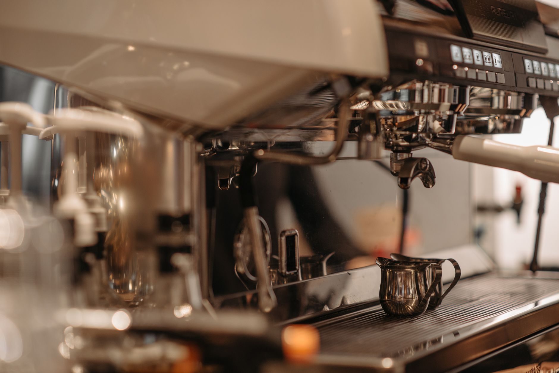 Close-up of a professional espresso machine with frothing pitcher, perfect for coffee lovers.