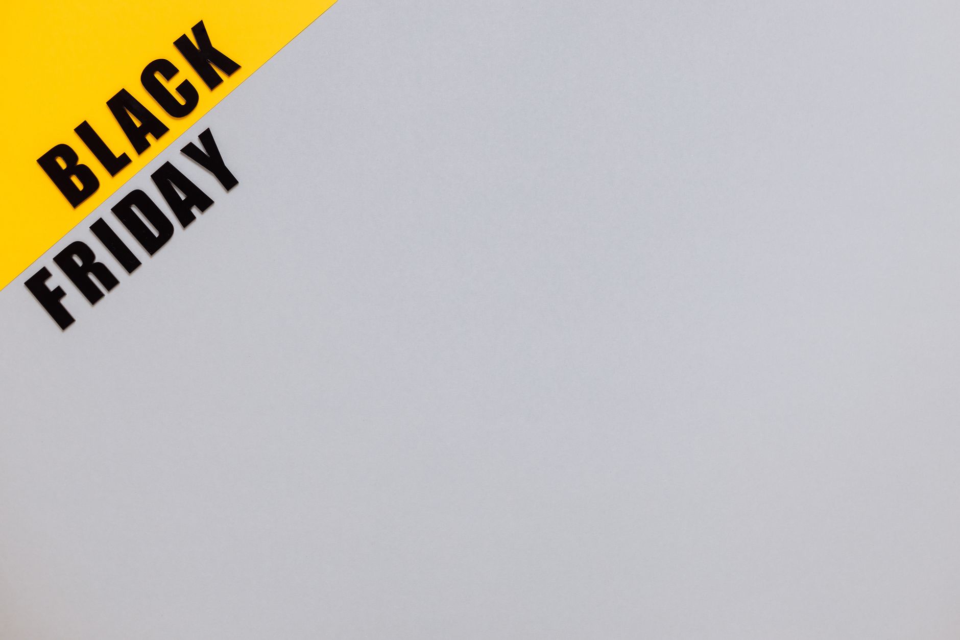 Minimalistic Black Friday banner on yellow and gray background with copy space.