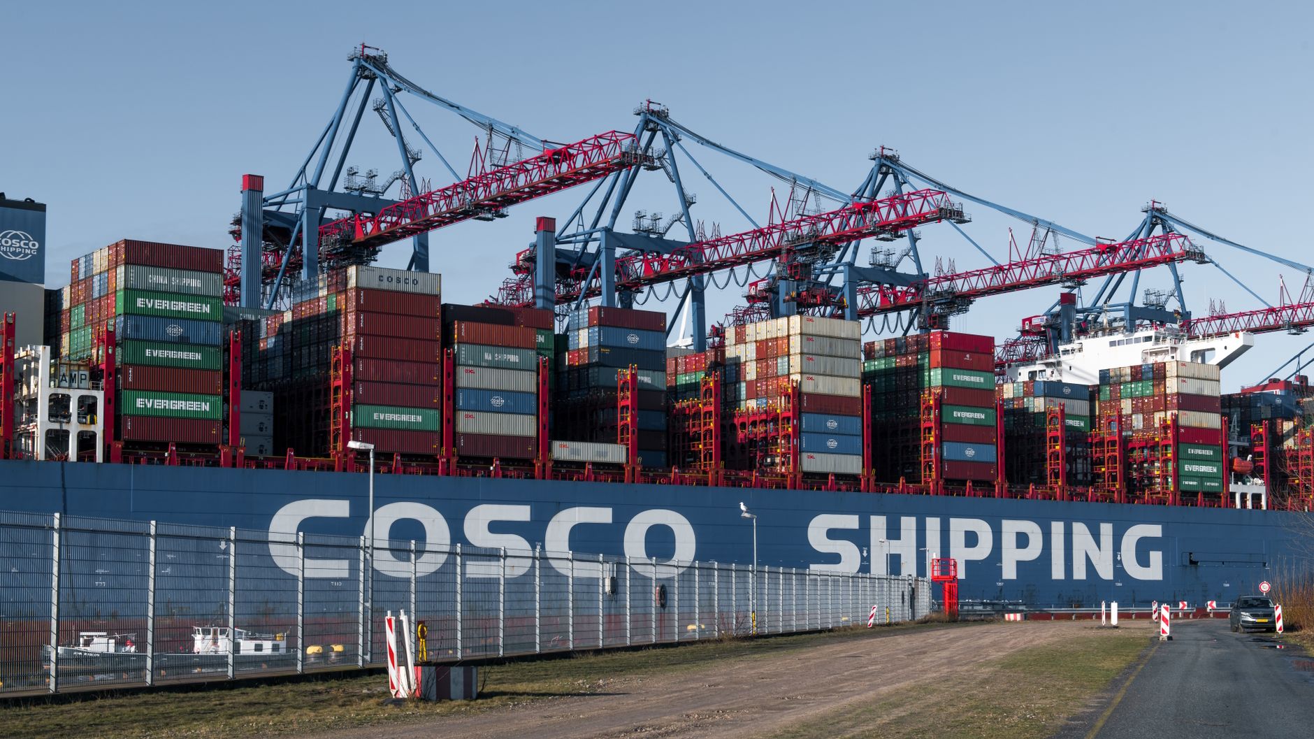 Large container ship and cranes at Hamburg port showcasing global trade and logistics operations.