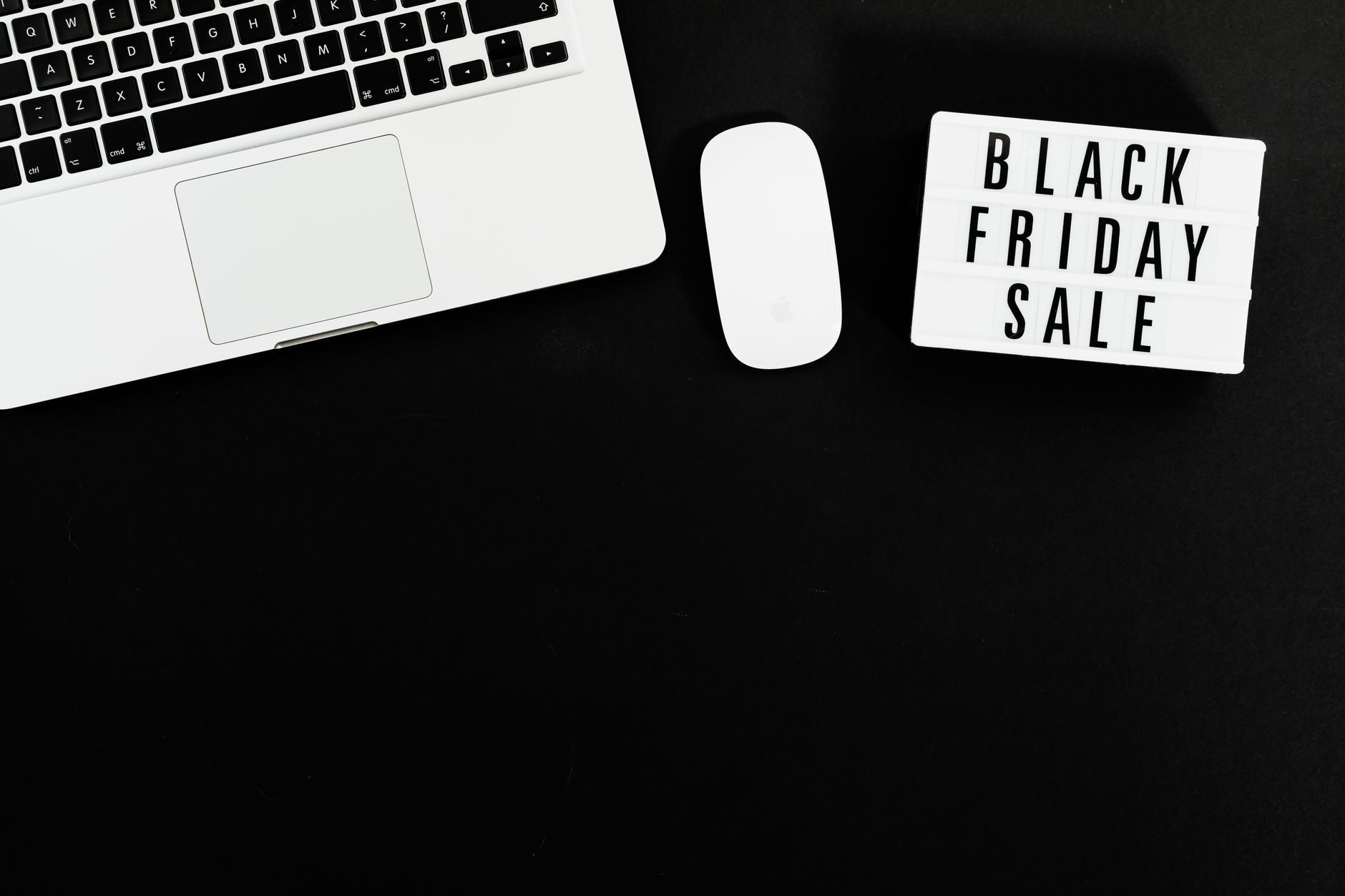 Black Friday sale sign with a laptop and mouse on a black background. Perfect for online shopping promotions.