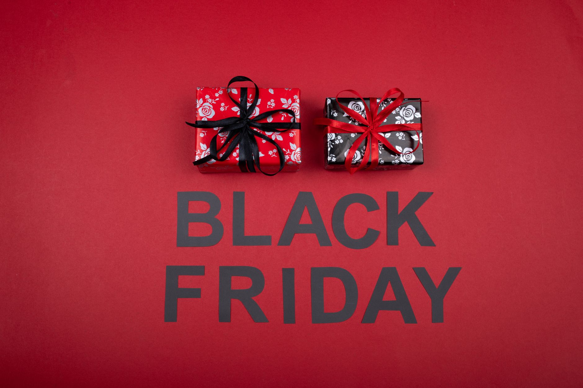Festive Black Friday promotion with gift boxes on a vibrant red background.