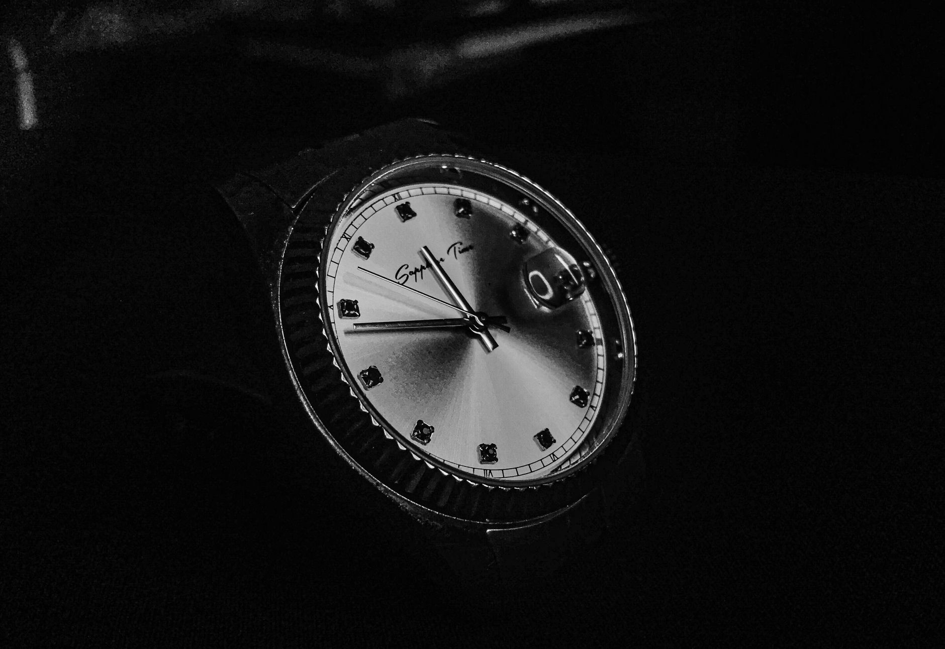 Monochrome close-up of a classic analog watch highlighting its detailed design.