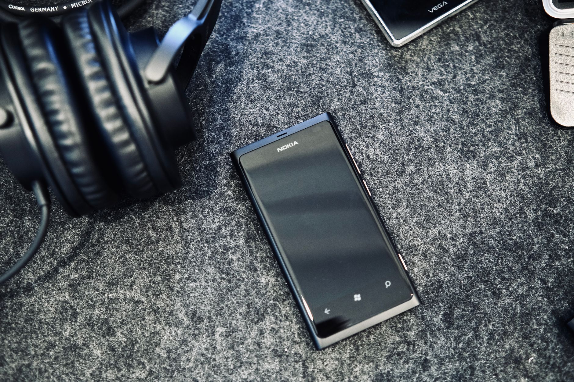Close-up of Nokia smartphone and headphones on grey surface, conveying modern technology concept.
