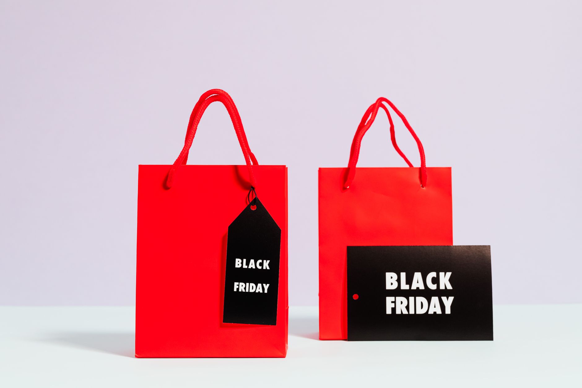Red shopping bags with Black Friday tags showcasing sale and discount theme.