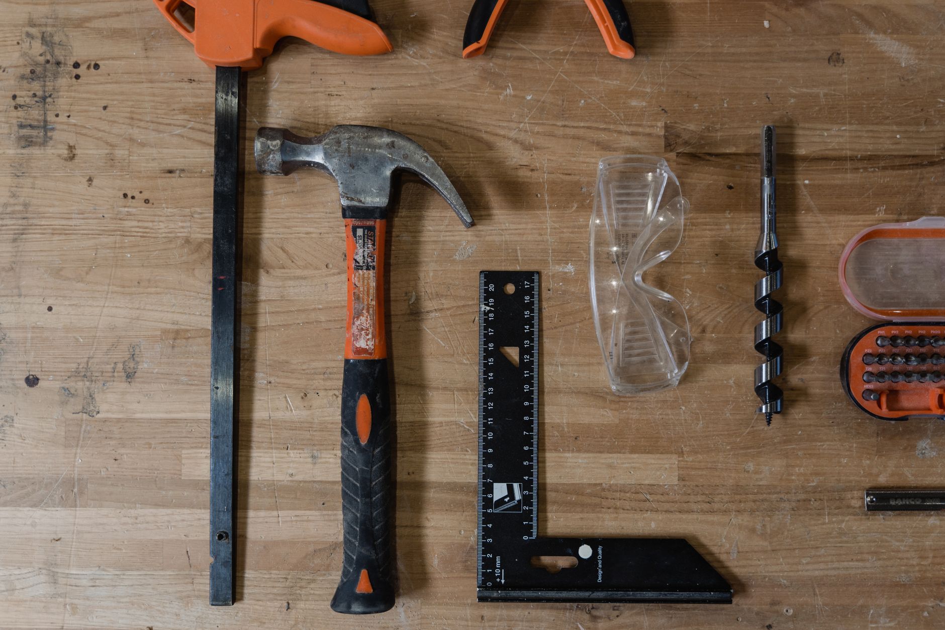 Flat lay of essential carpentry tools on wooden table.