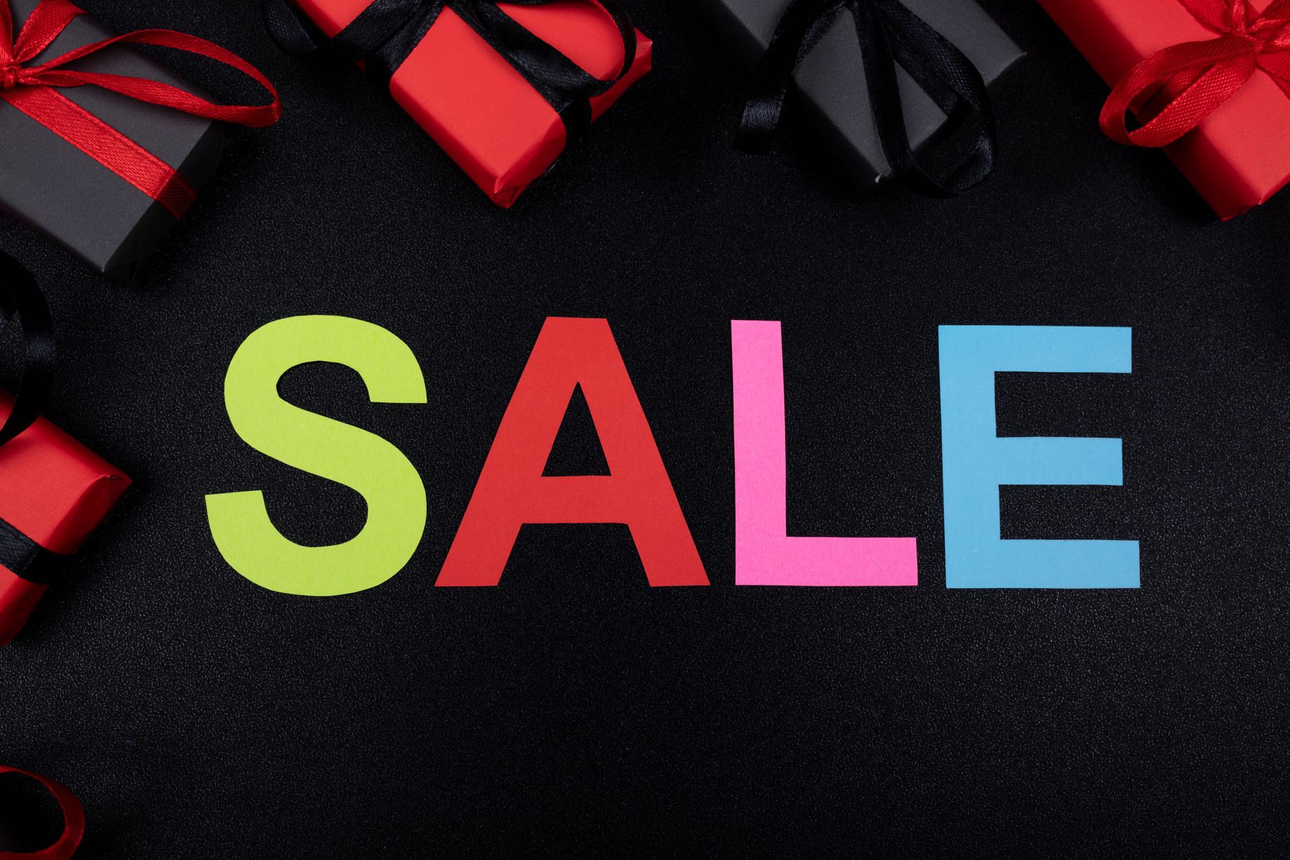 Vibrant SALE text surrounded by gift boxes offers perfect promotional imagery.