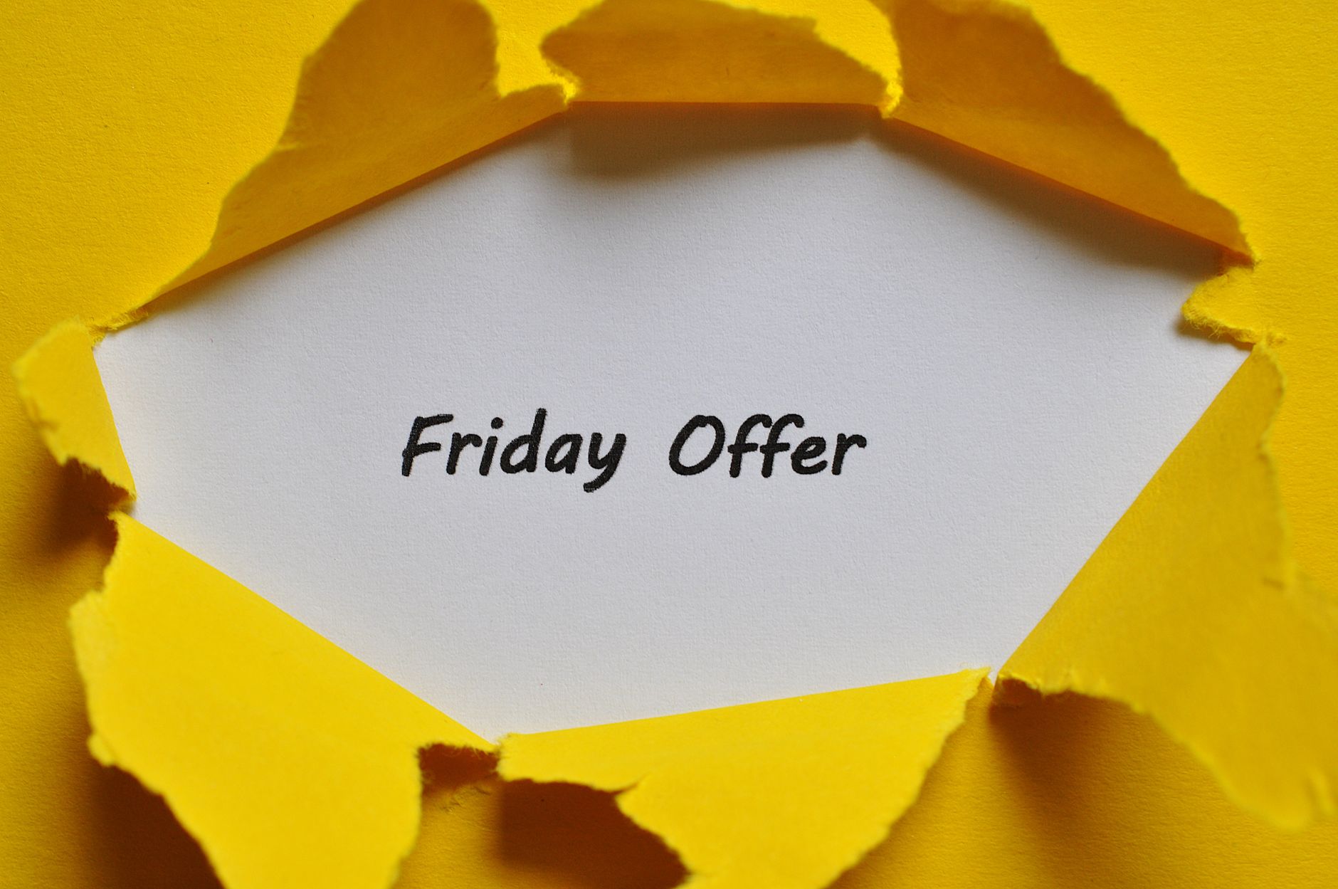 Yellow torn paper reveals Friday offer message, perfect for promotions.