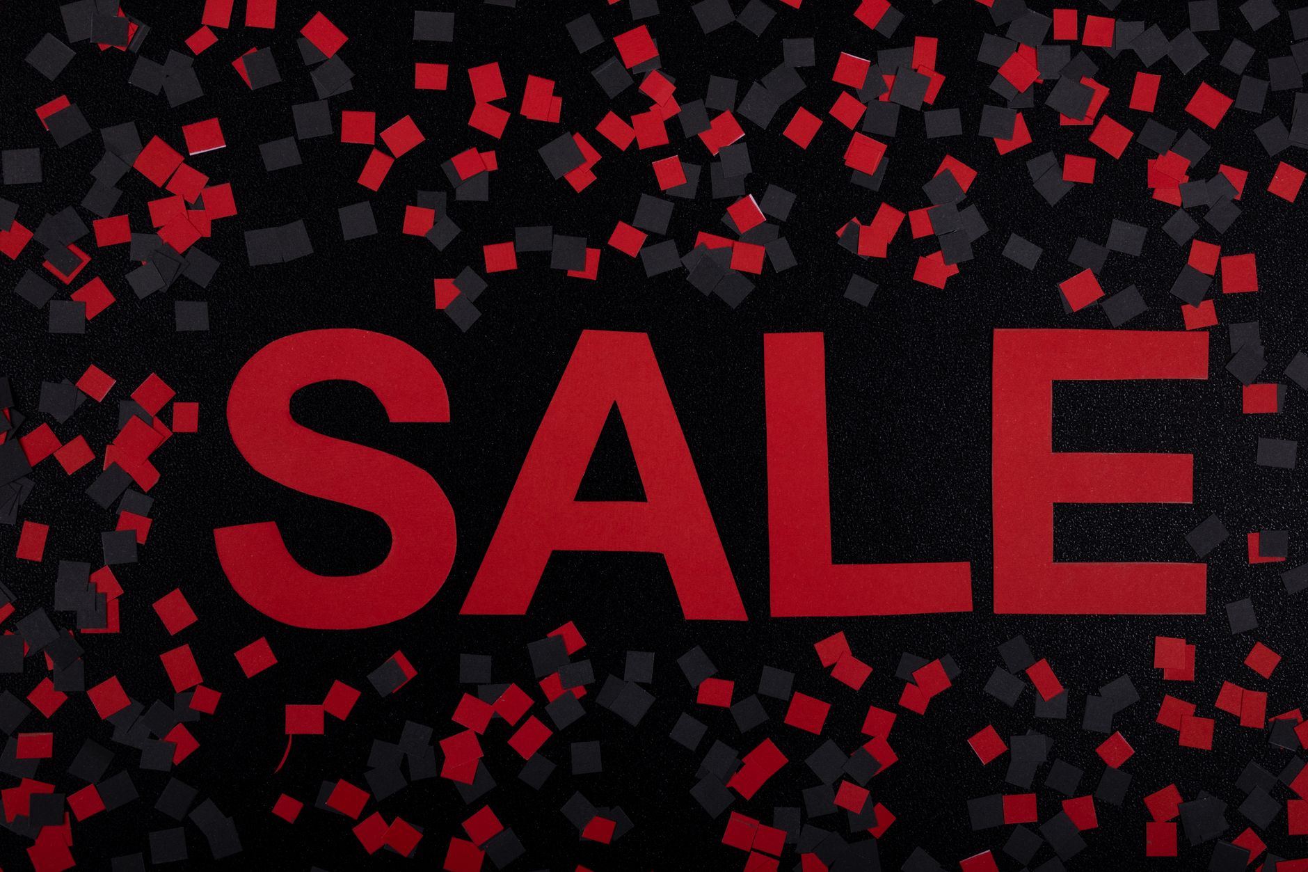 Vibrant sale banner with red text and confetti. Perfect for marketing promotions.