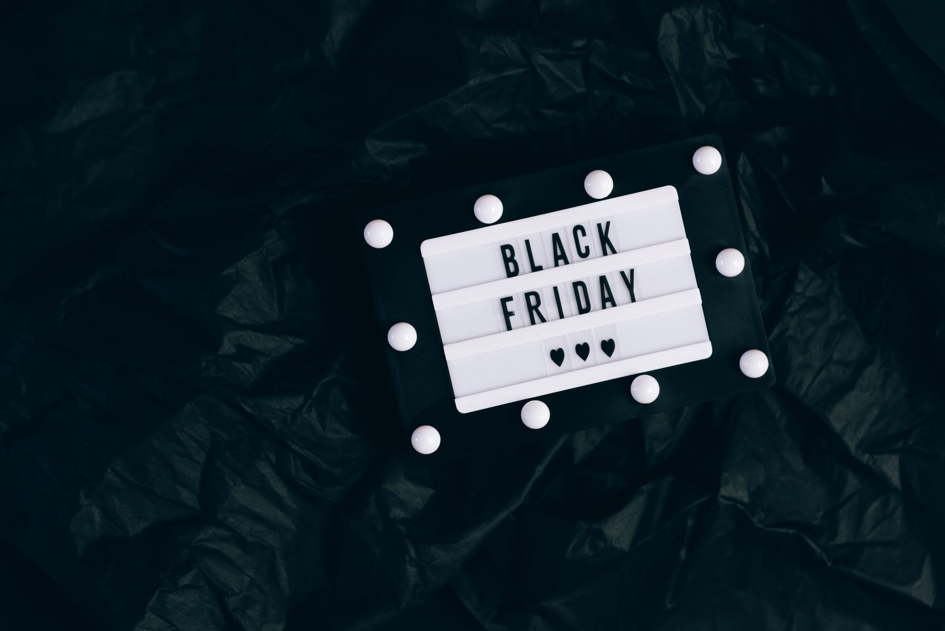 Black Friday promotion sign with lights on a dark textured background, perfect for shopping ad.