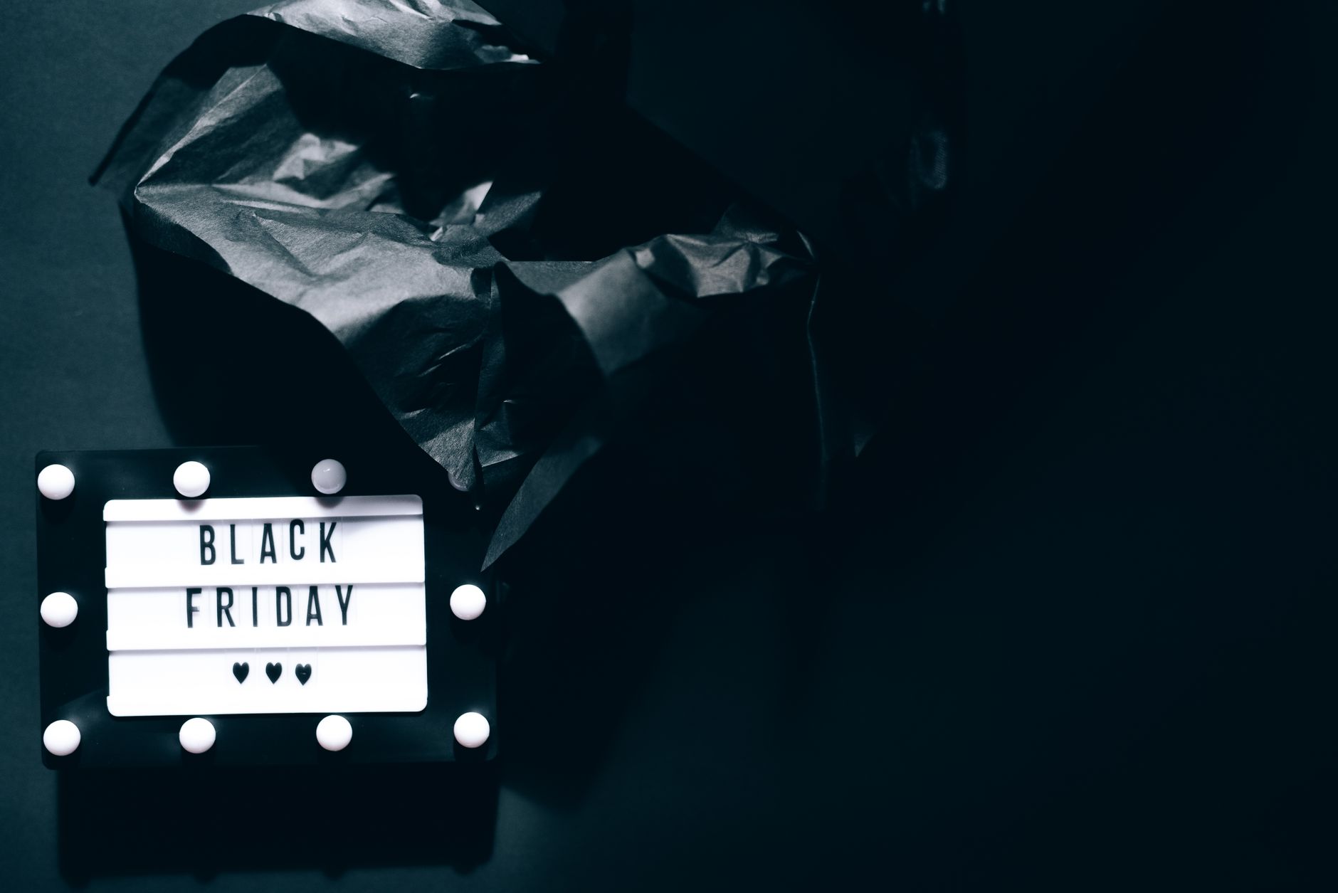 Illuminated Black Friday sign on dark background with dramatic lighting for sales promotions.