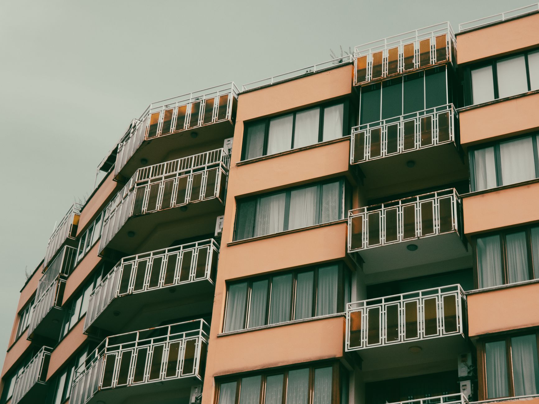 A contemporary apartment building with balconies in an urban setting.