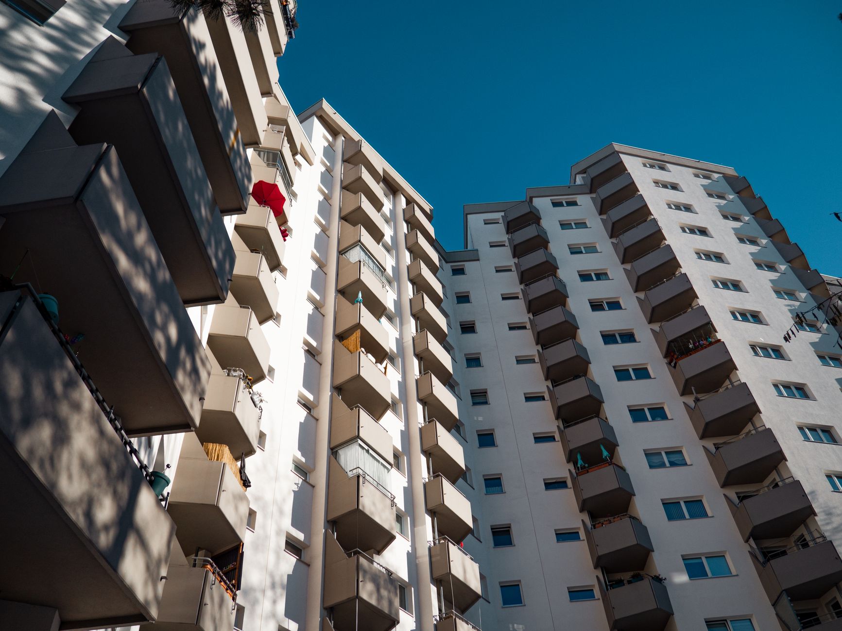 Low-angle view of modern residential apartment buildings in Berlin under clear sky.