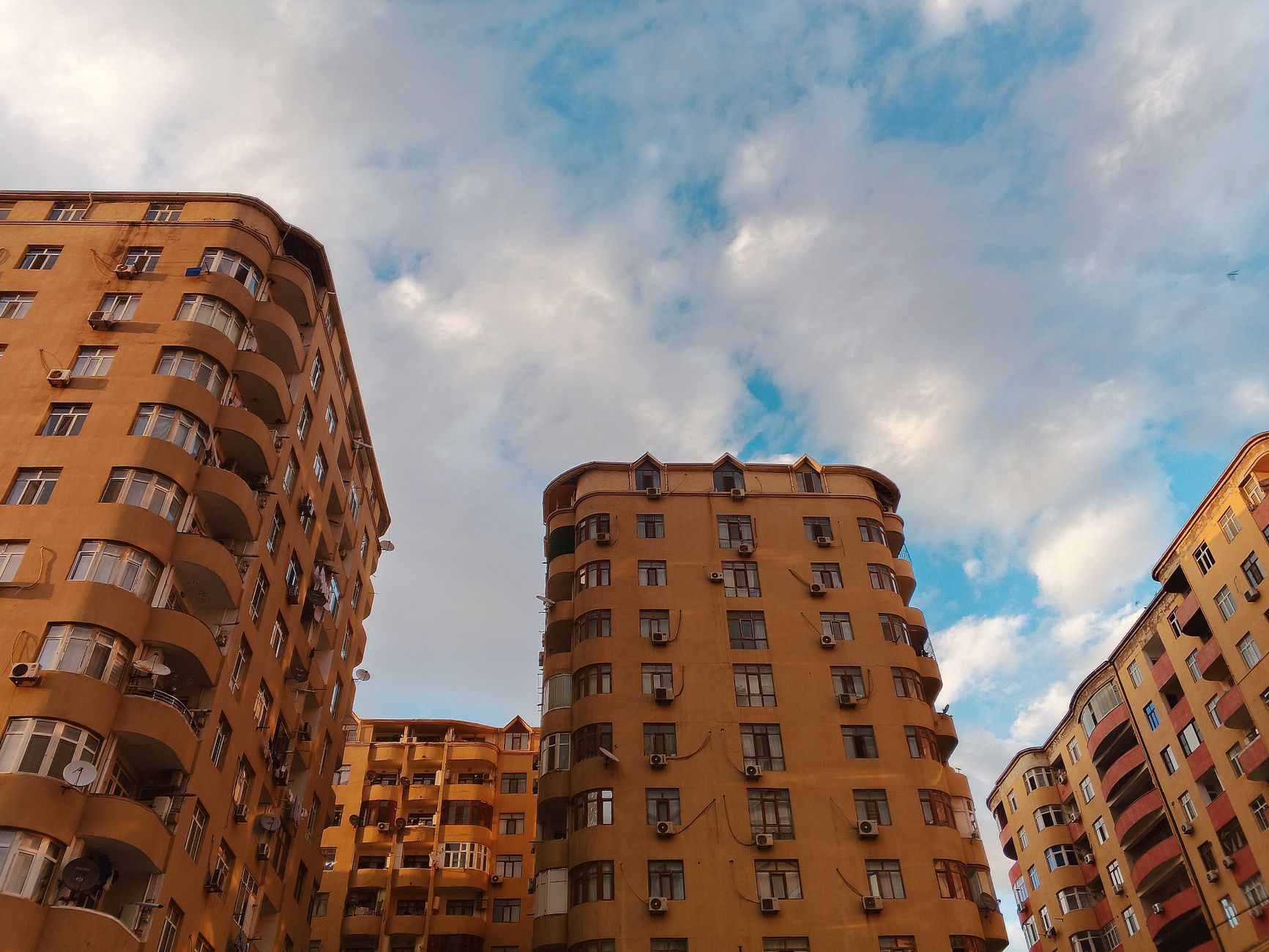 Residential high-rise buildings with a vibrant blue sky, showcasing urban architecture.