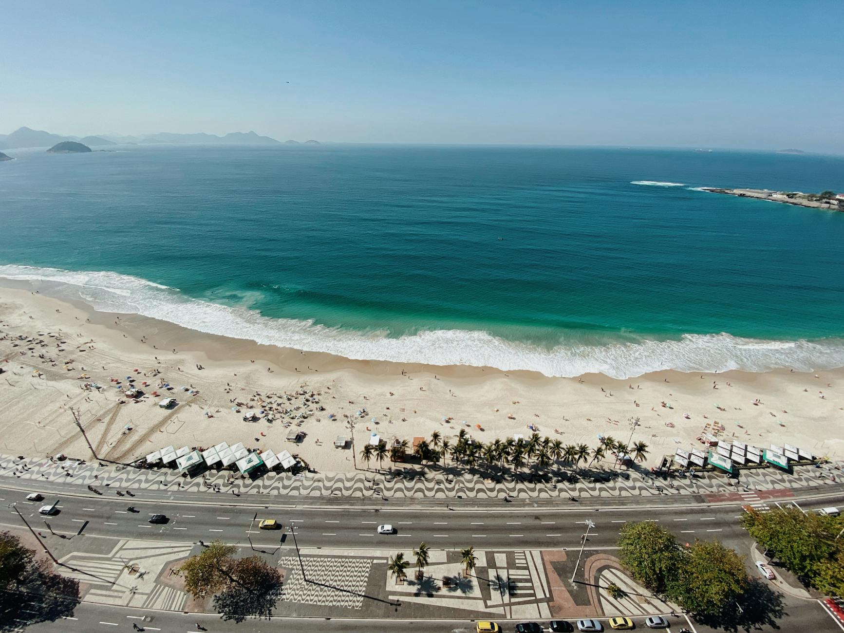 Stunning aerial view of iconic Copacabana Beach with teal ocean and waving patterns in Rio de Janeiro.