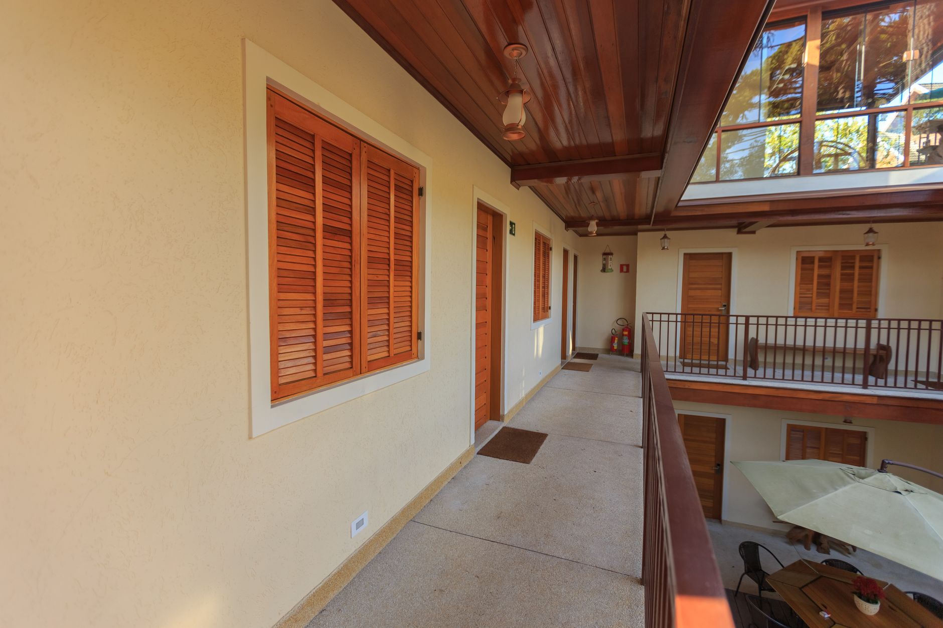 Spacious hotel courtyard featuring wooden doors, windows, and minimalist design.
