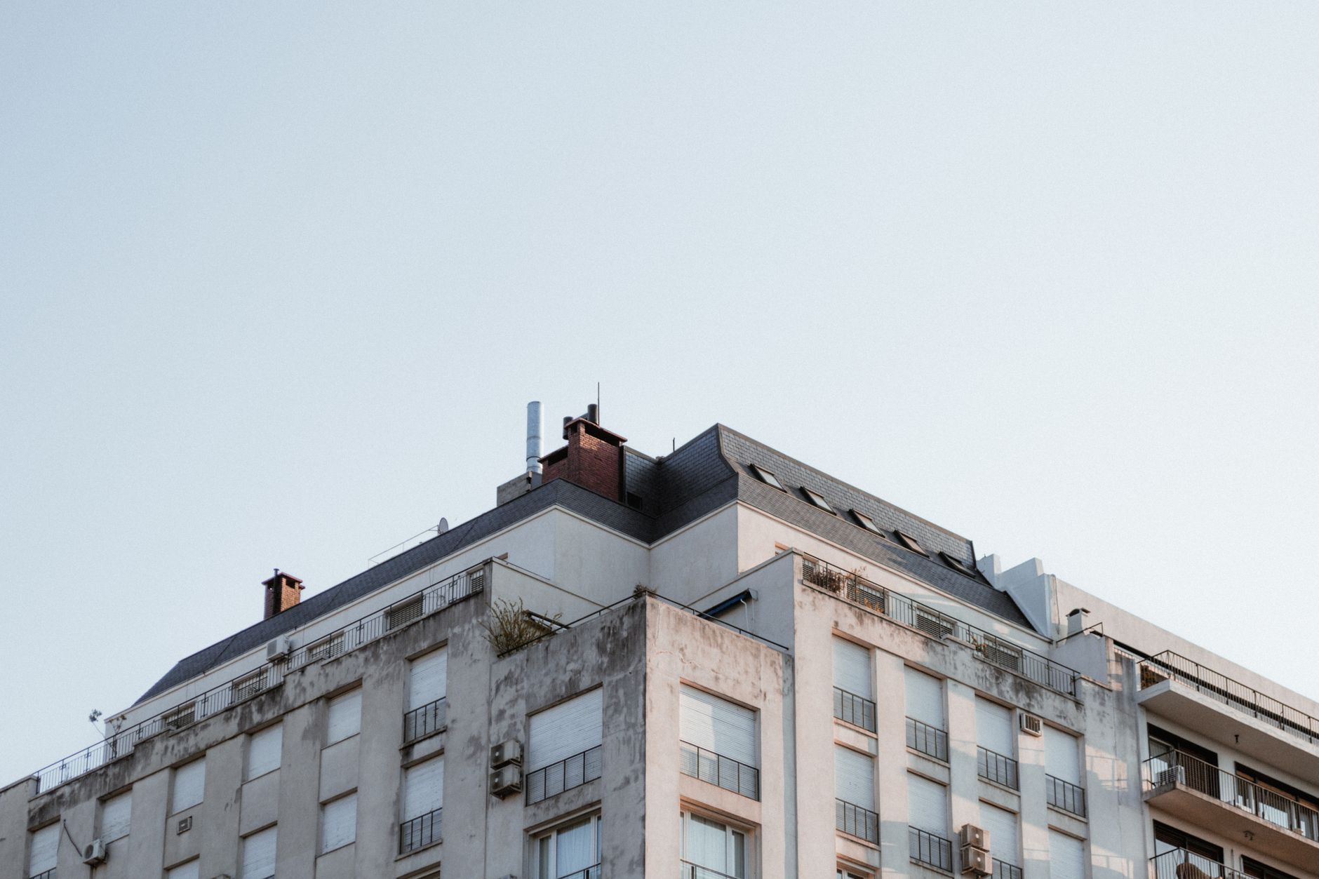 Top view of a modern apartment building in Buenos Aires with a clear blue sky background.