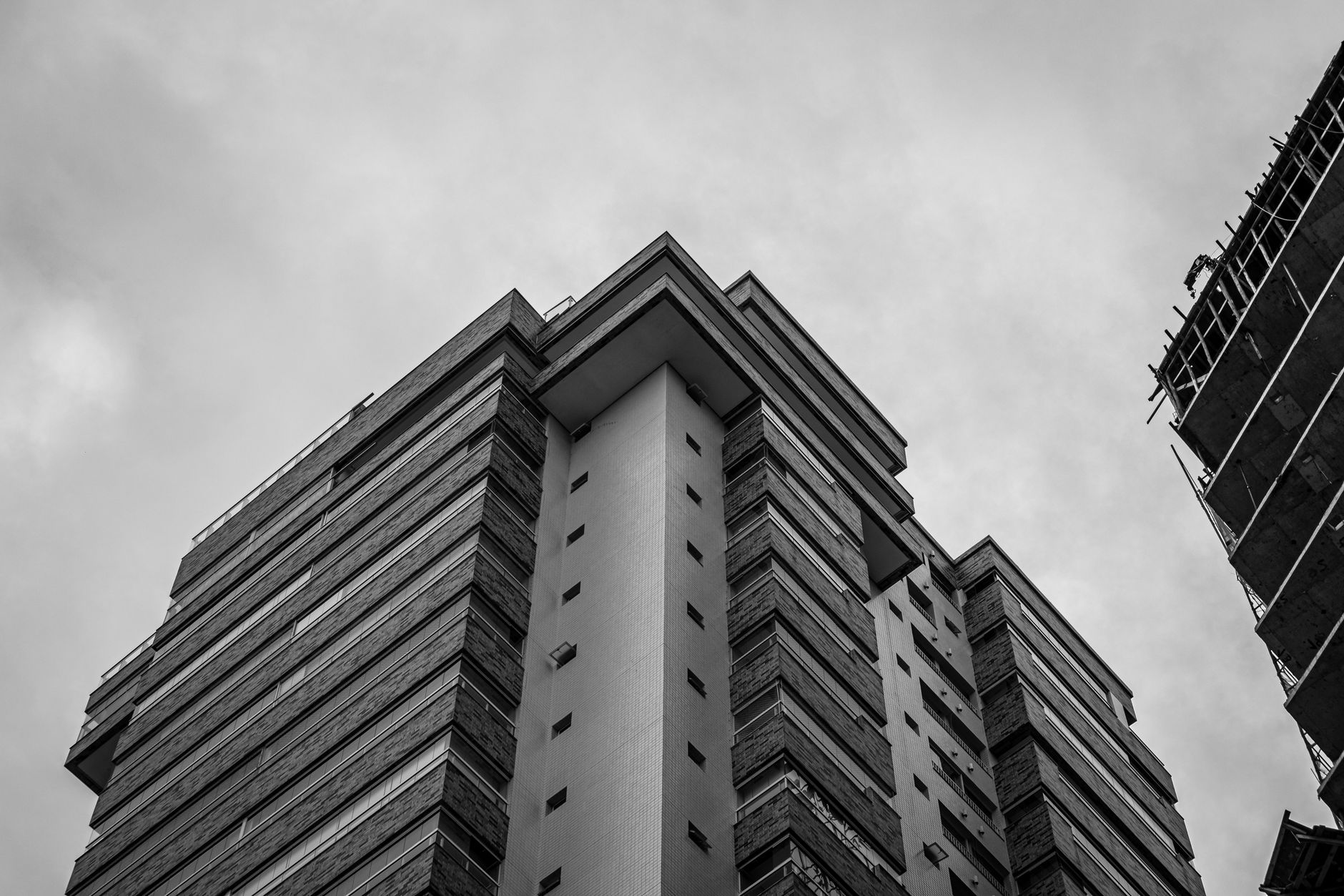 Striking black and white photo of modern skyscraper, emphasizing urban architecture in Praia Grande, São Paulo.