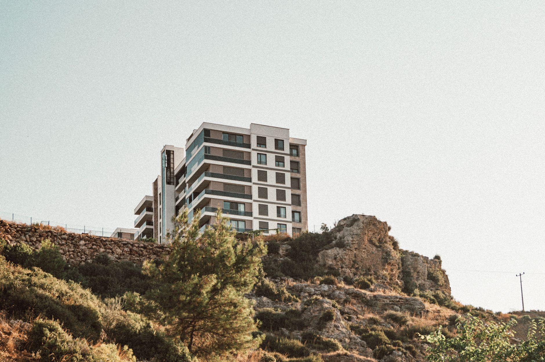 A modern residential building dominates the landscape with its contemporary architecture on a scenic cliff