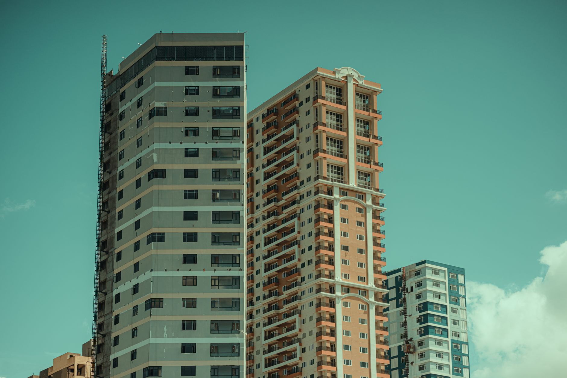 Modern high-rise residential buildings with unique facades against a clear sky.