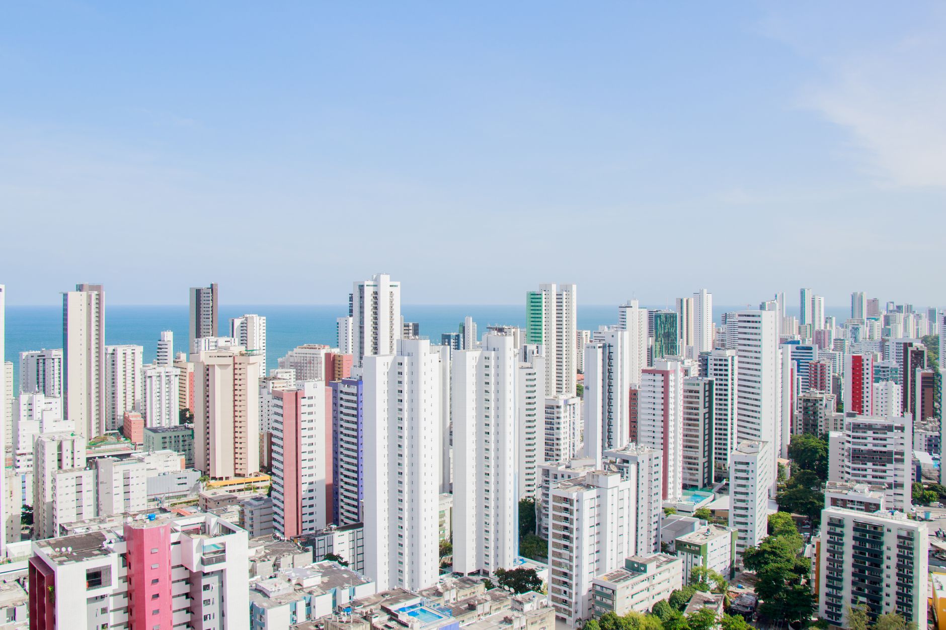 A panoramic view of Recife's skyline featuring modern skyscrapers and the Atlantic Ocean.