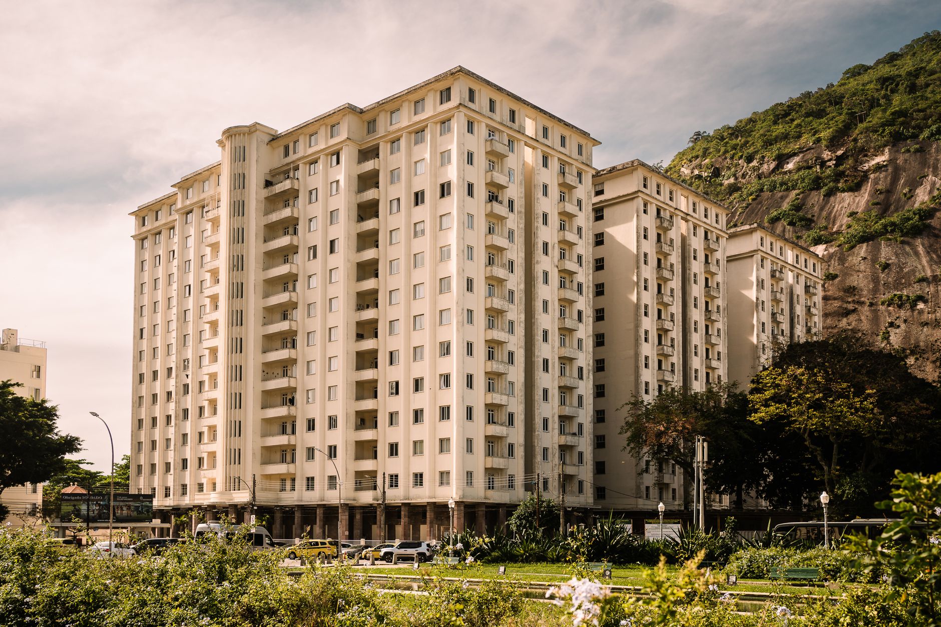 A contemporary residential building in Rio de Janeiro with a scenic mountain backdrop and clear skies.