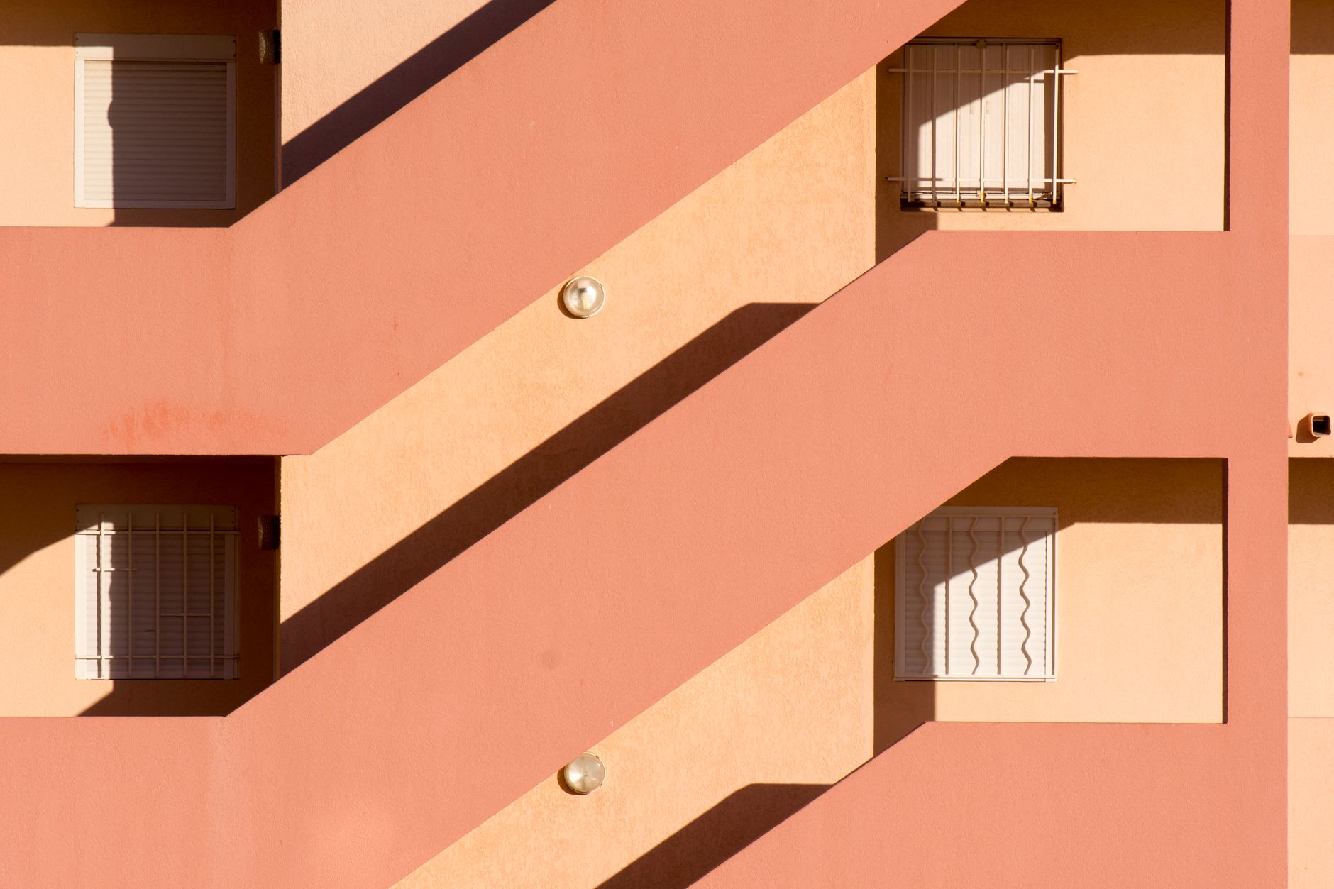 Minimalist facade of a residential building featuring striking geometric shapes and vibrant colors.
