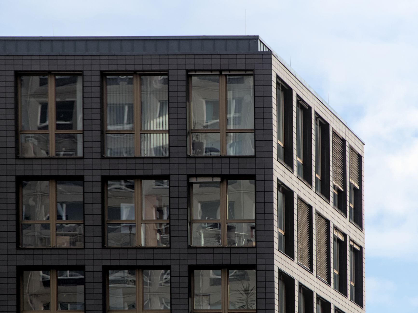 Corner view of a modern office building in Berlin with glass windows and a clear sky.