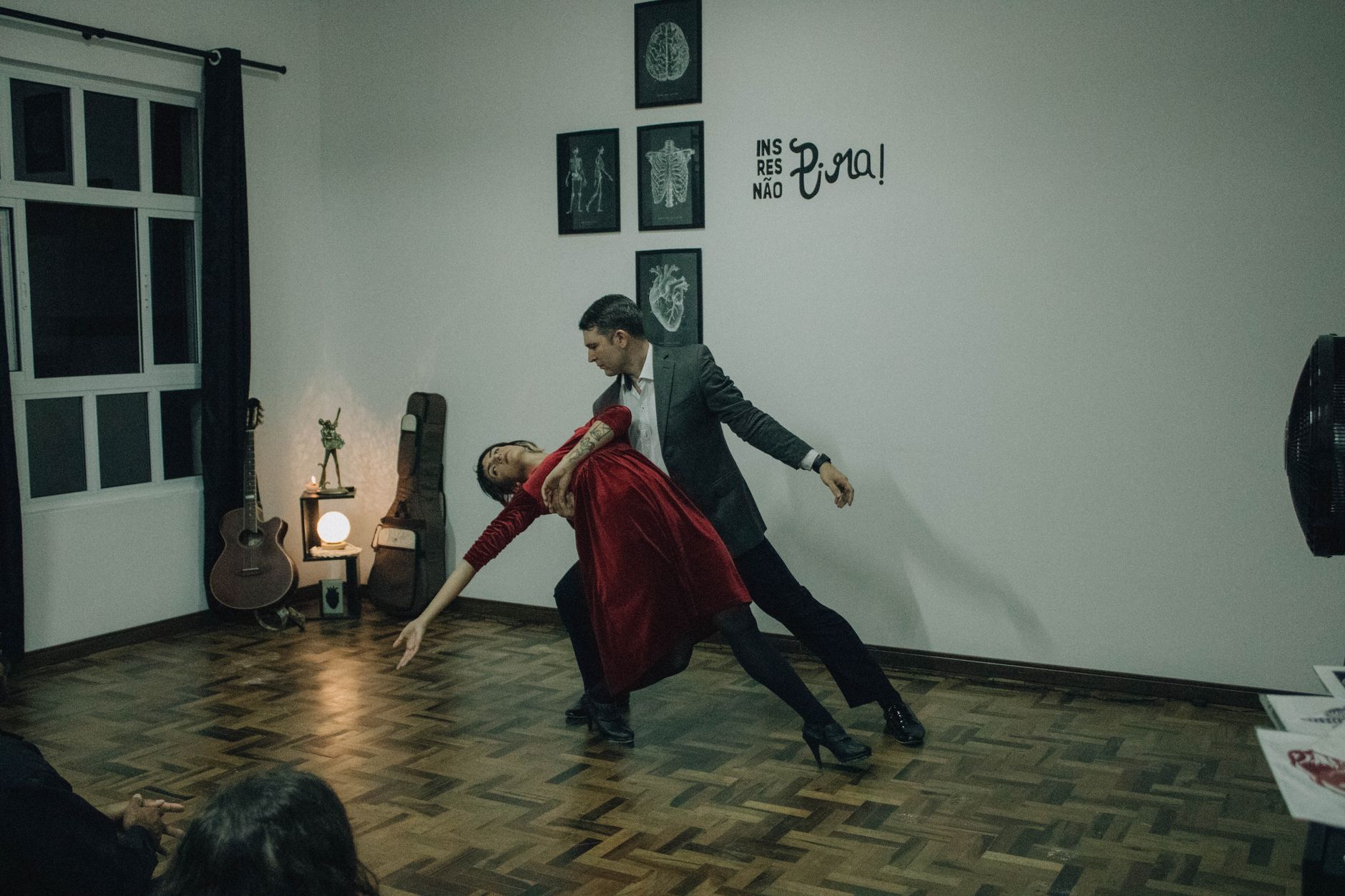 A couple skillfully performing tango in a stylish living room setting.