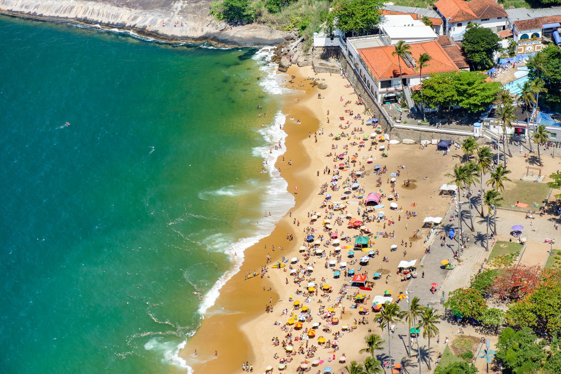 Vibrant aerial shot of Ipanema Beach, Rio de Janeiro, crowded with beachgoers on a sunny day.