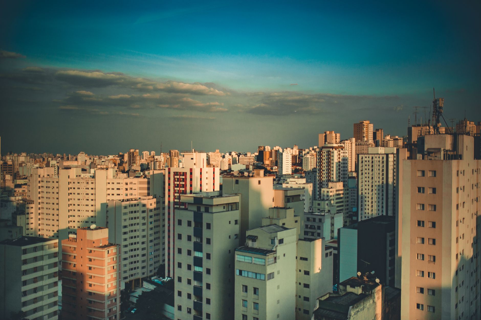 Stunning aerial view of a bustling cityscape with skyscrapers under a clear blue sky.