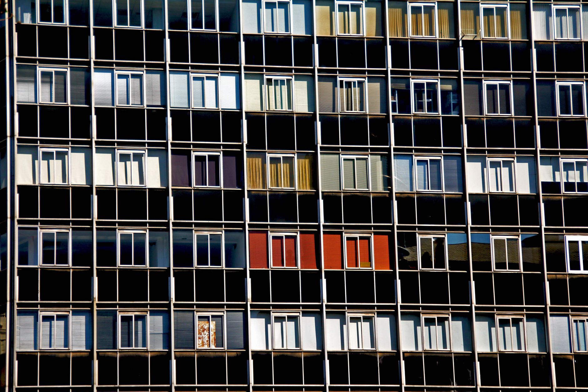 A vibrant facade of a modern apartment building with varied window colors and patterns.