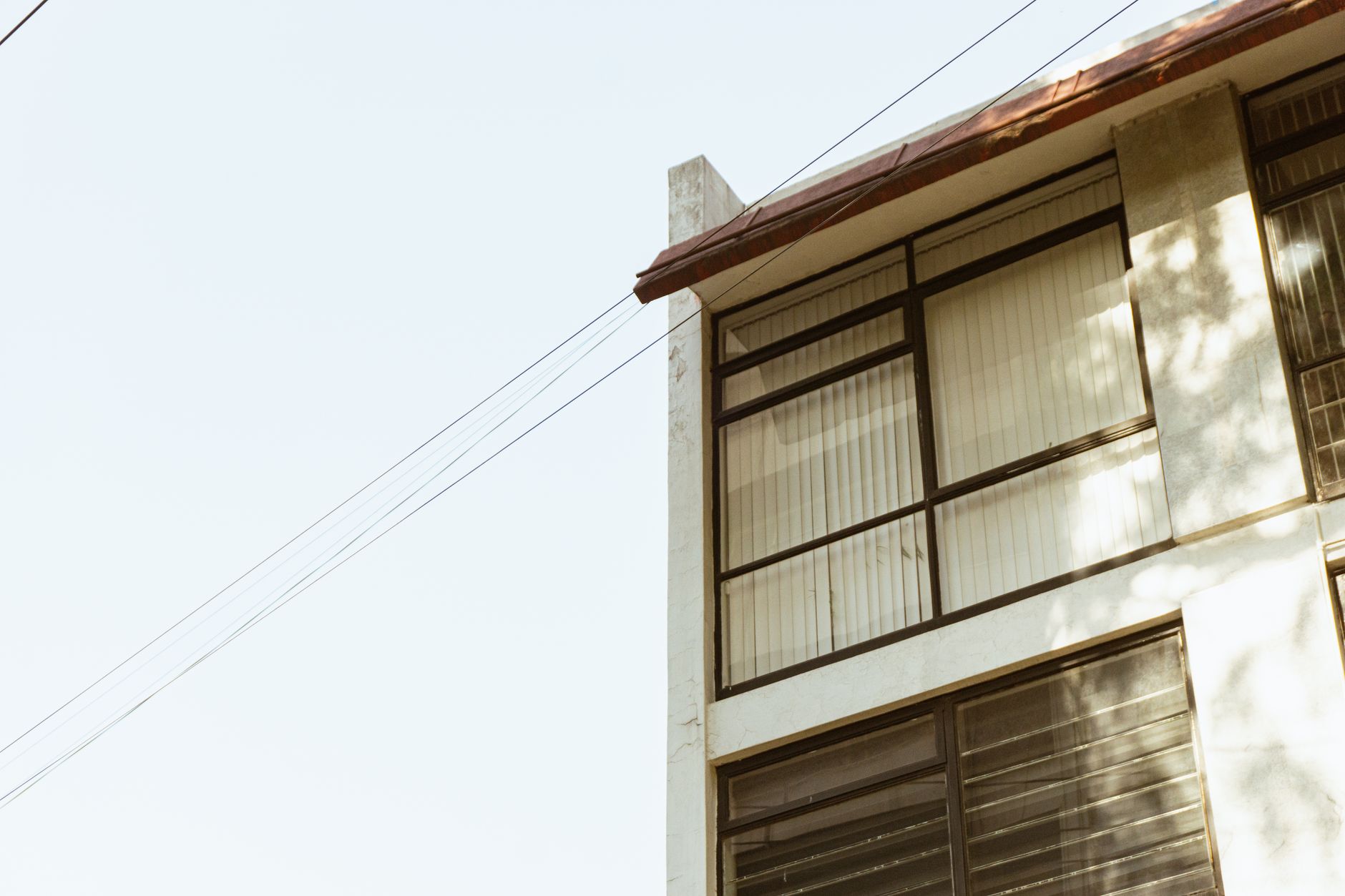 Side view of a contemporary building with large windows and clear sky.