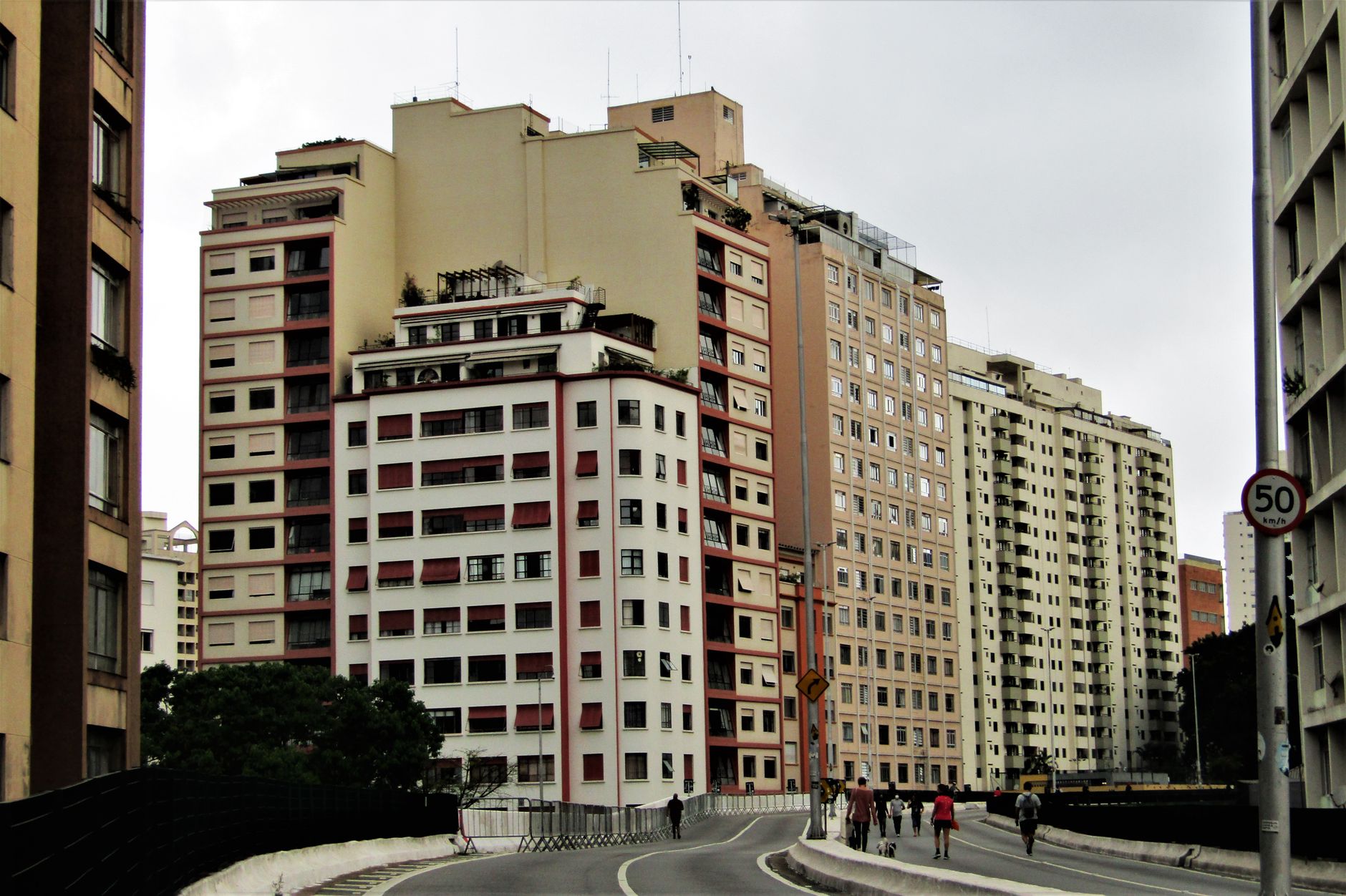 View of a city street with multiple modern buildings and pedestrians.