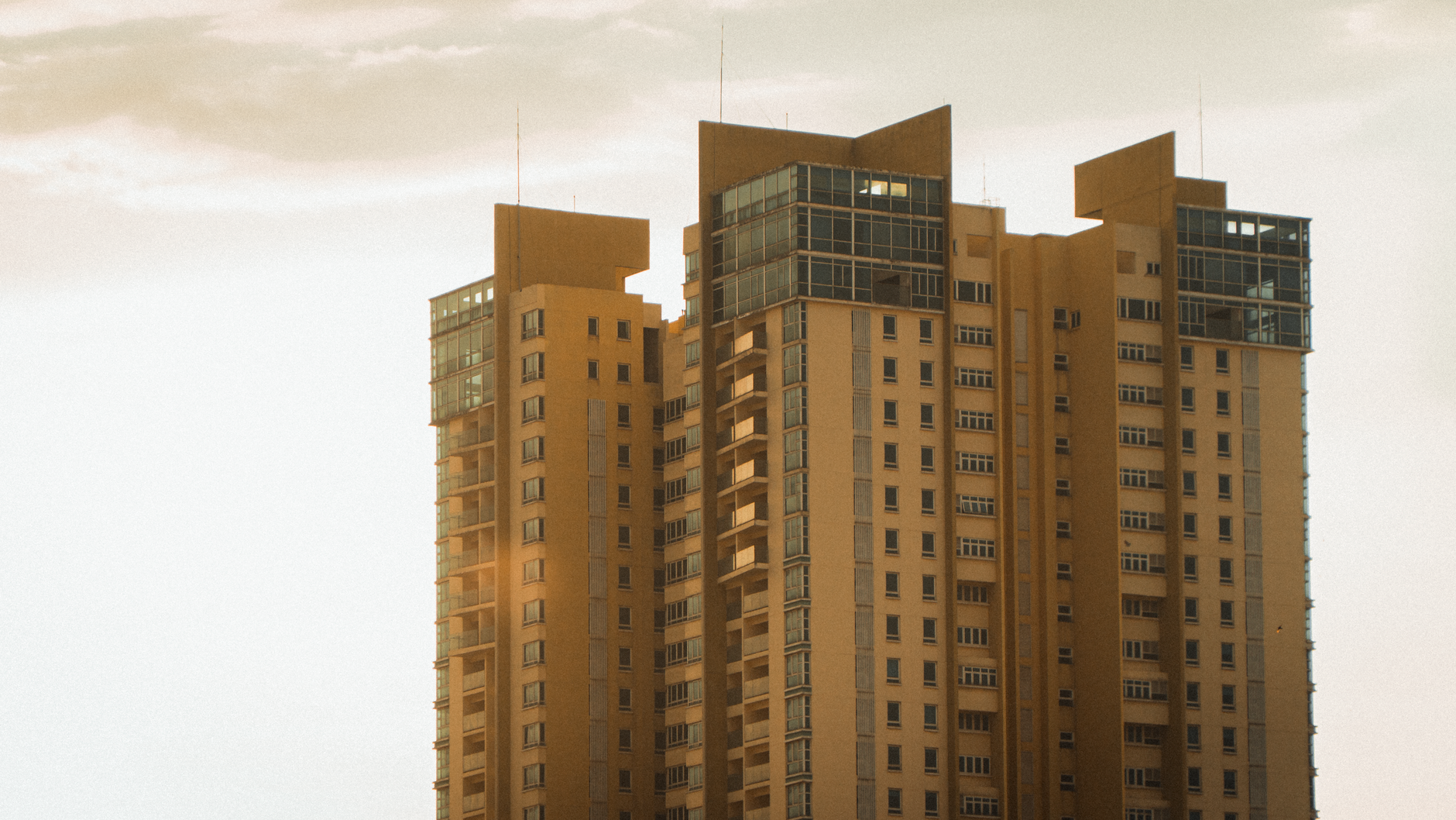 Urban high-rise building captured at sunset with warm tones and modern architecture.