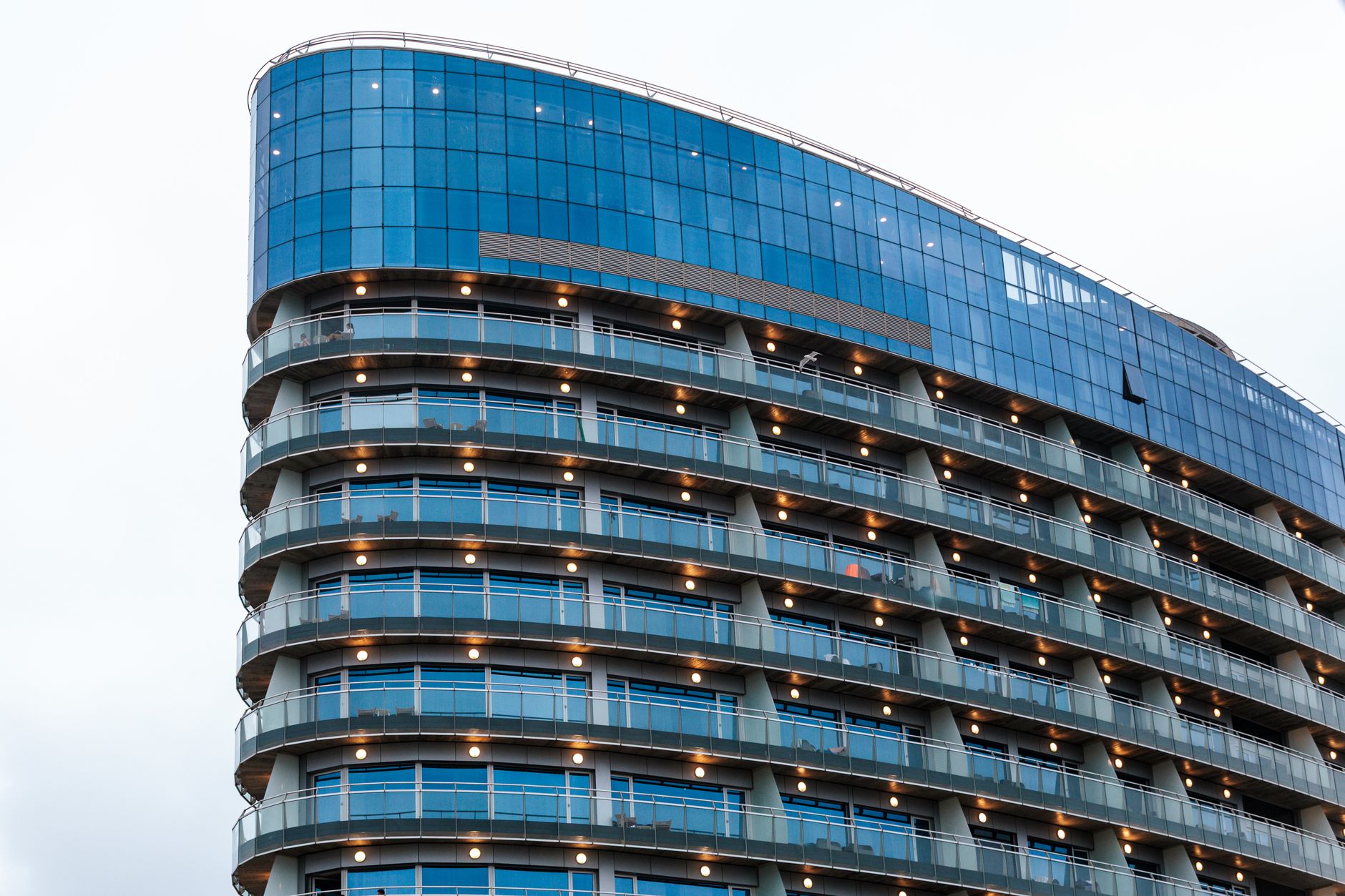 Photograph of a modern high-rise building with a distinctive glass facade and architectural design.