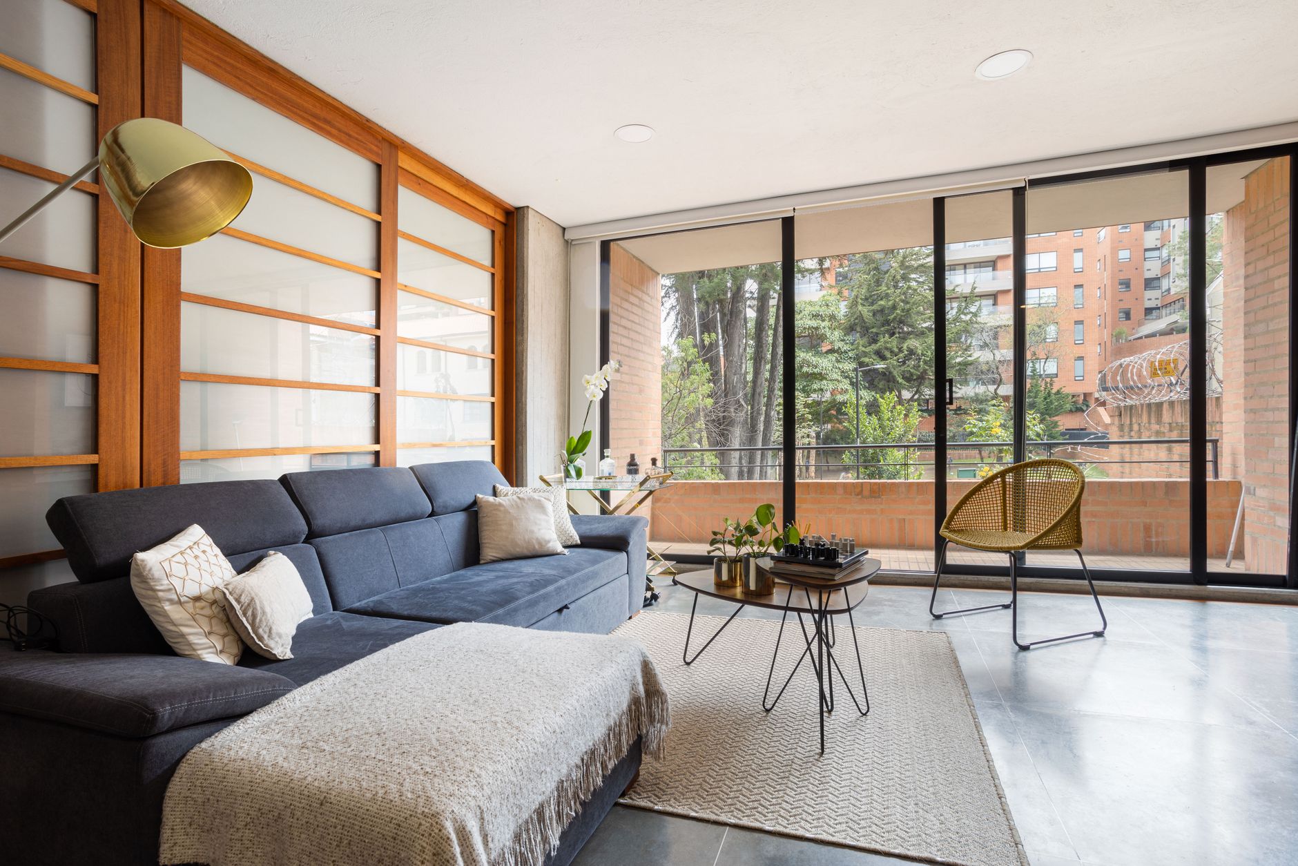 Stylish living room with contemporary furniture and large windows offering a cityscape view in Bogotá.