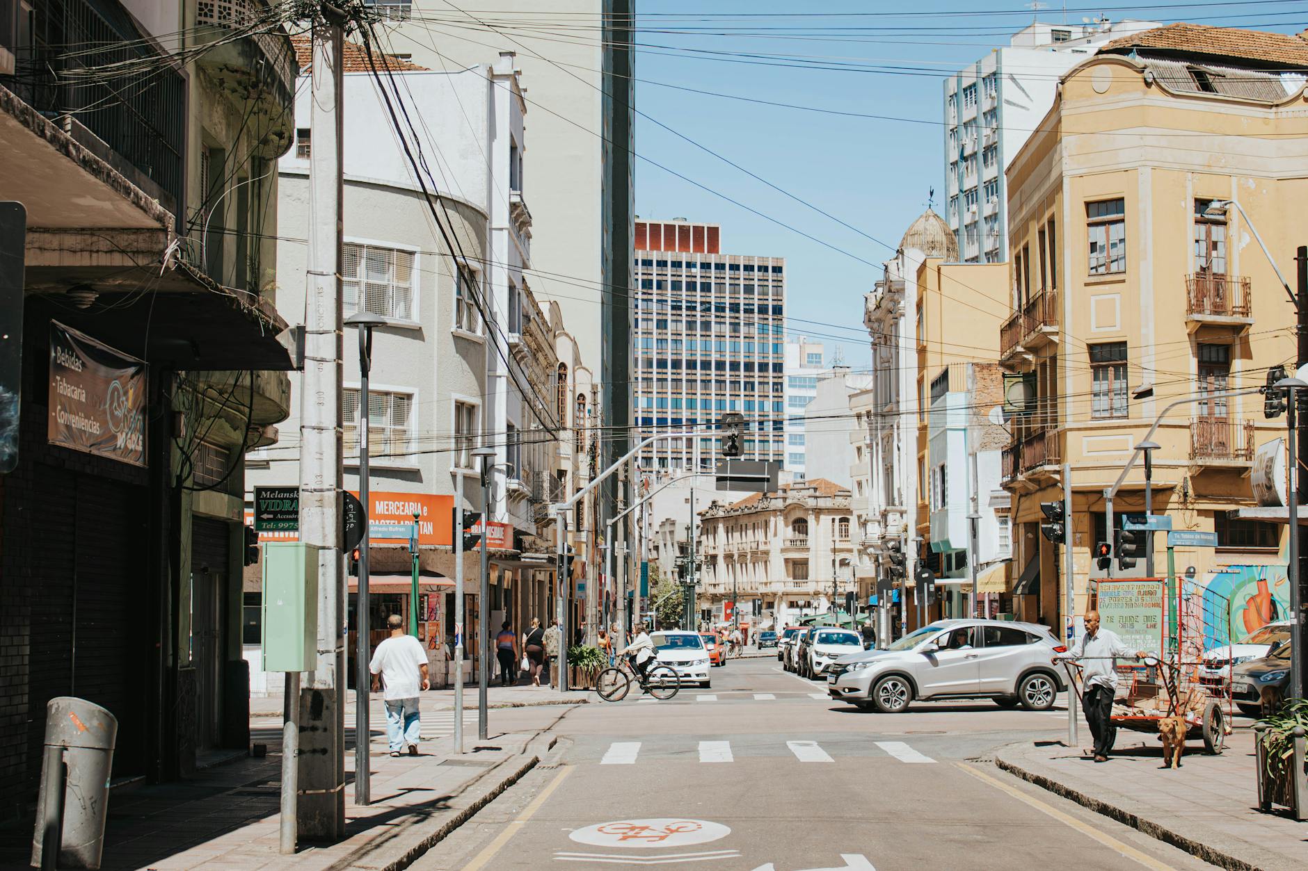 Lively intersection in Curitiba's cityscape with vehicles and pedestrians.