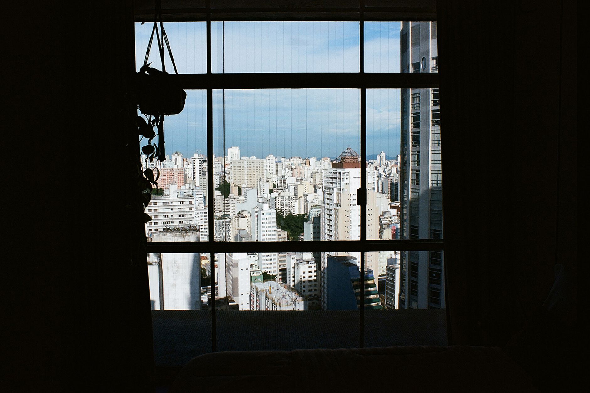 View of a bustling city skyline through a window, capturing a modern urban landscape.
