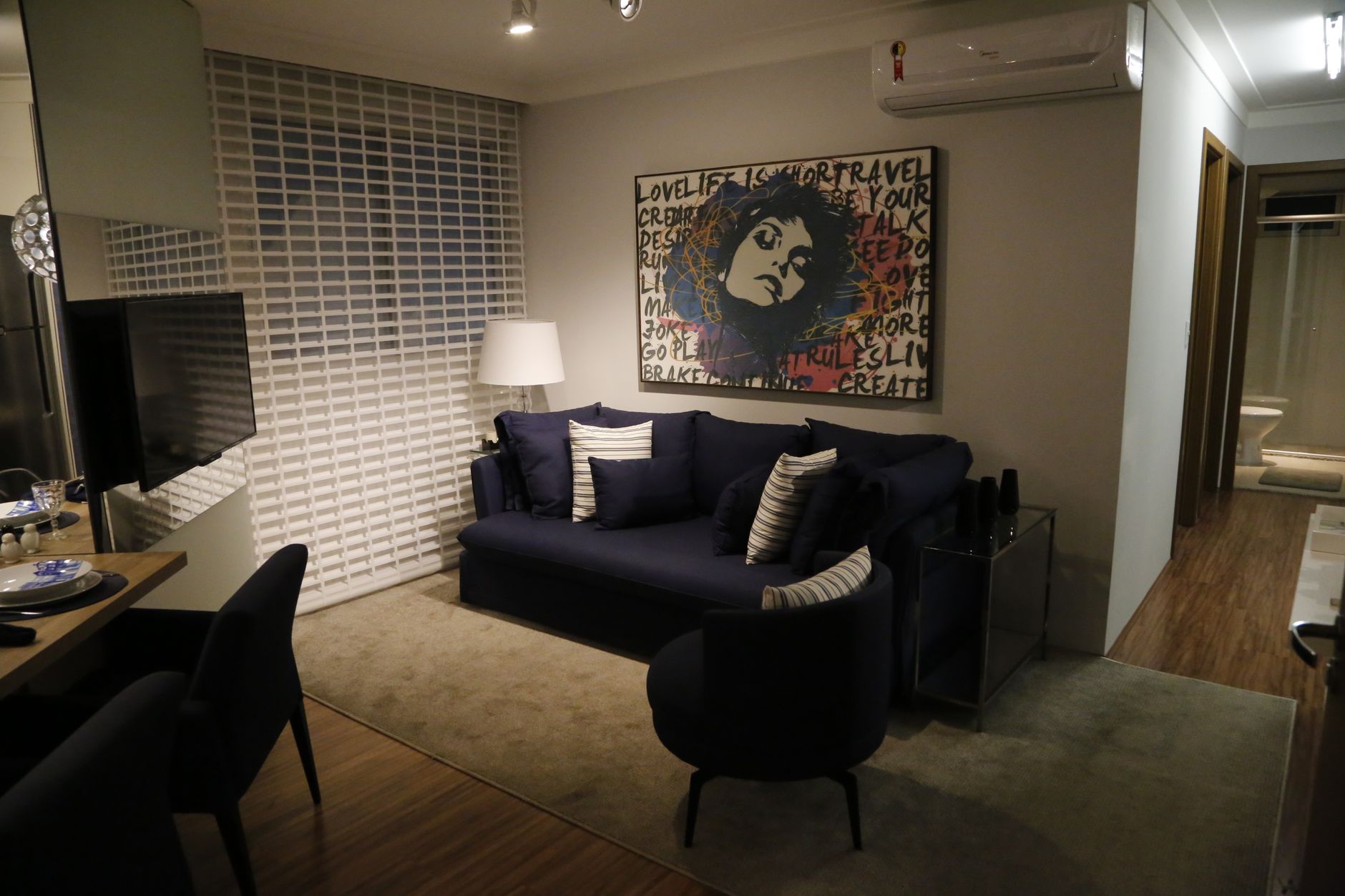 Modern living room with blue sofa, stylish art, and contemporary decor. Cozy and elegant interior design.