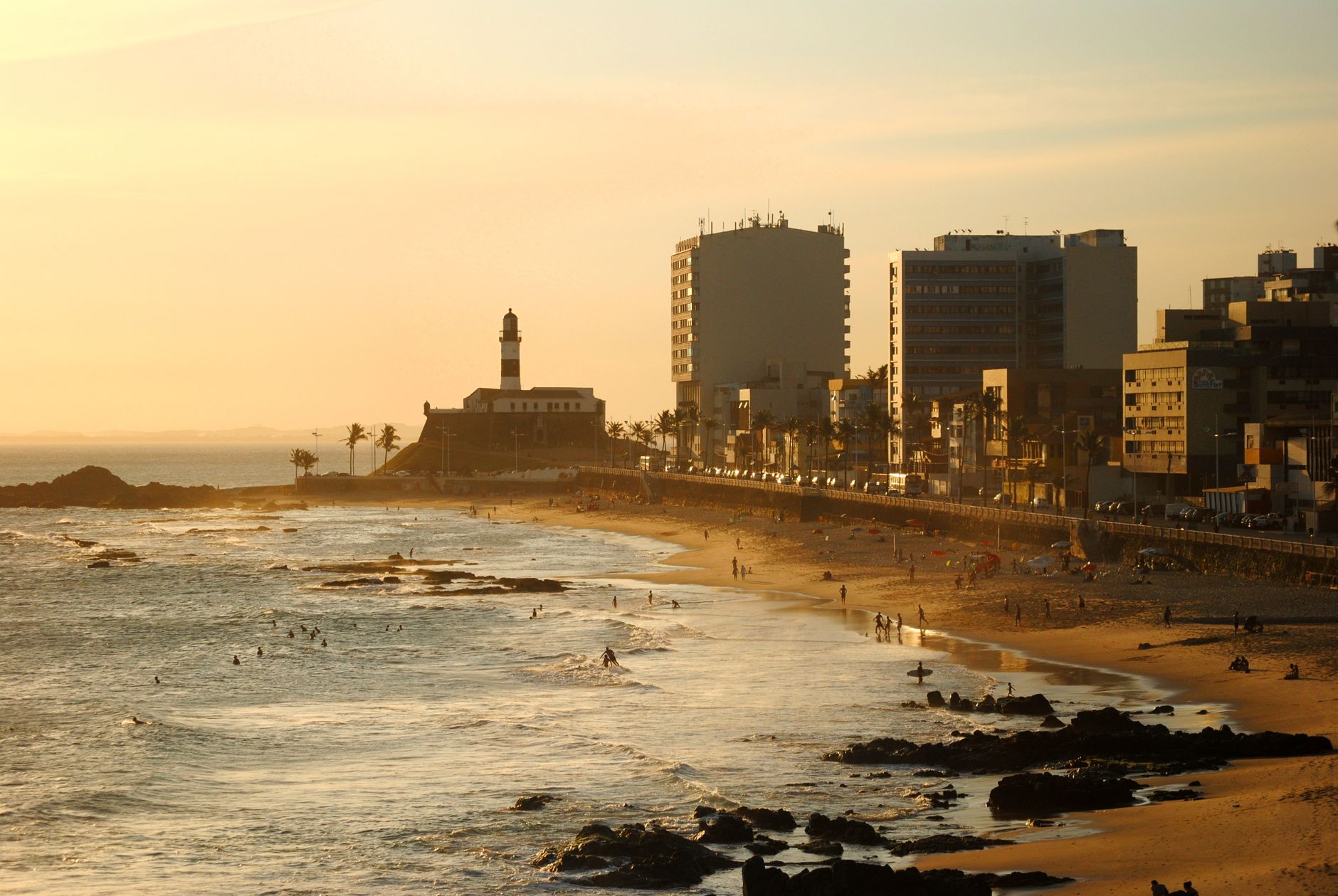 A stunning view of Barra Beach at sunset with the famous Farol da Barra lighthouse.