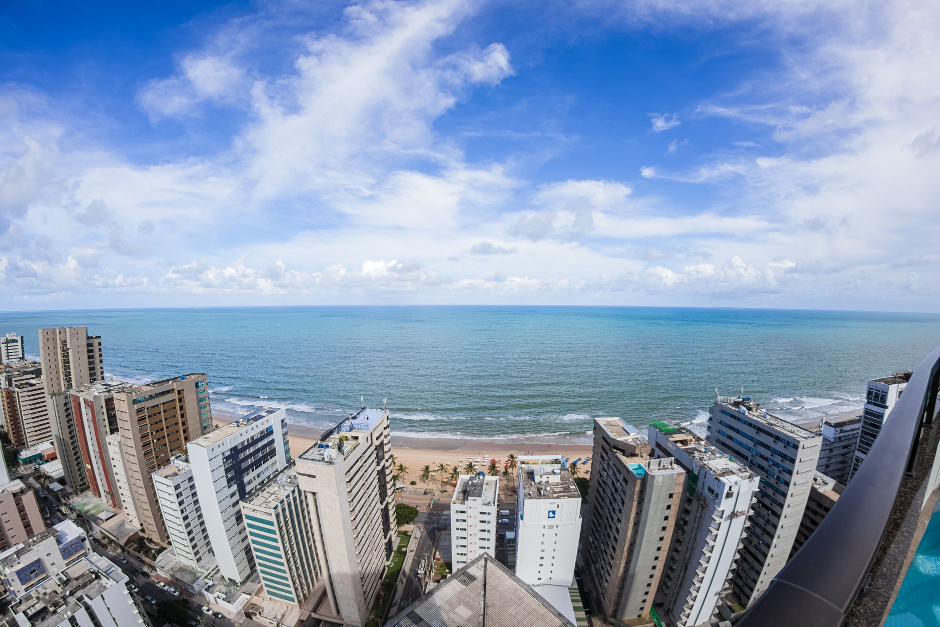 Stunning aerial view of Recife's urban coastline, showcasing modern architecture against the ocean.