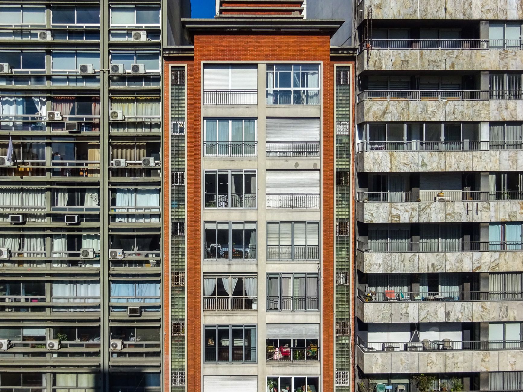 Detailed view of high-rise apartment buildings showcasing diverse architectural styles and window designs.
