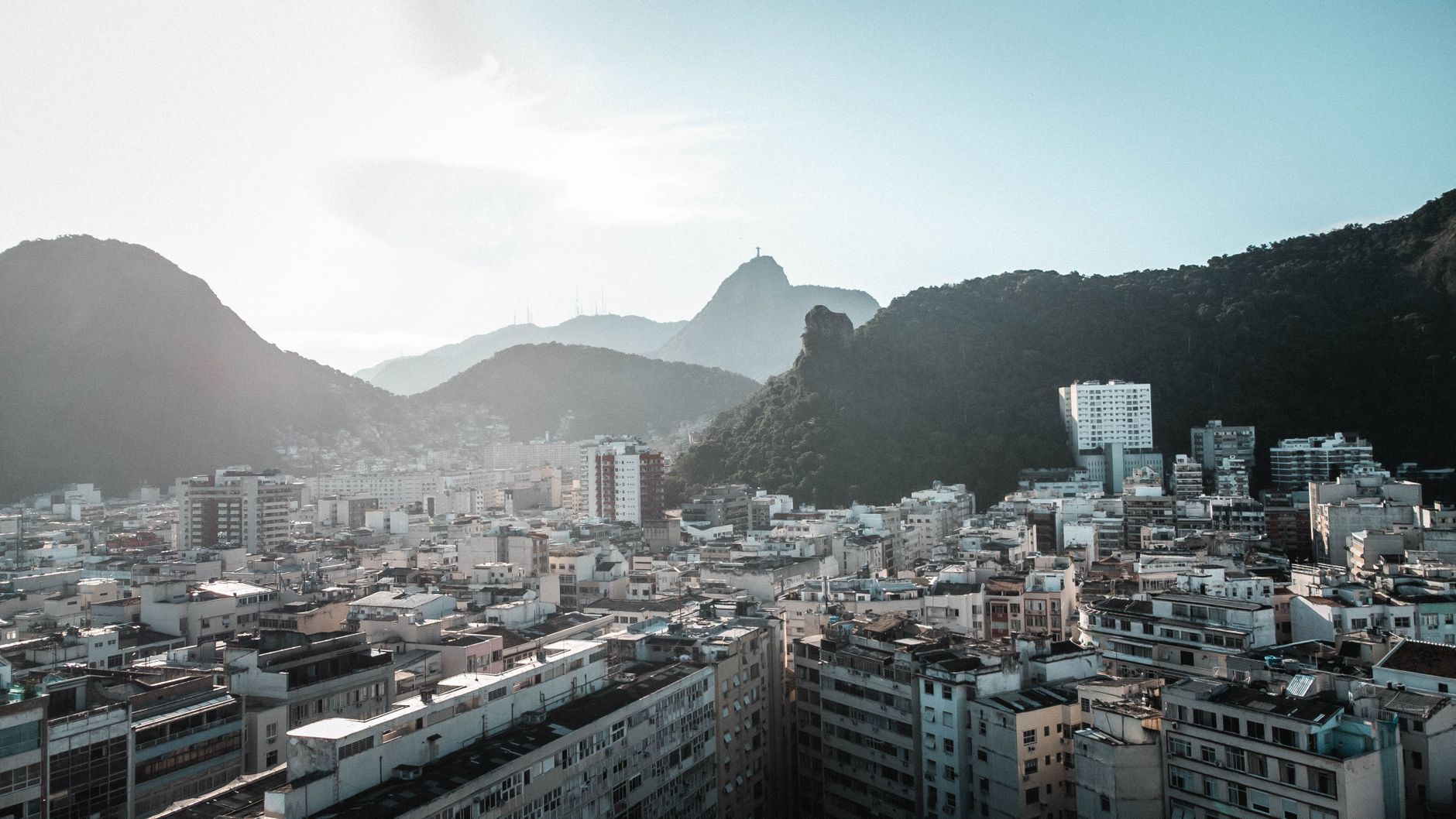 Stunning aerial view of Rio de Janeiro city with mountains in the background under bright daylight.