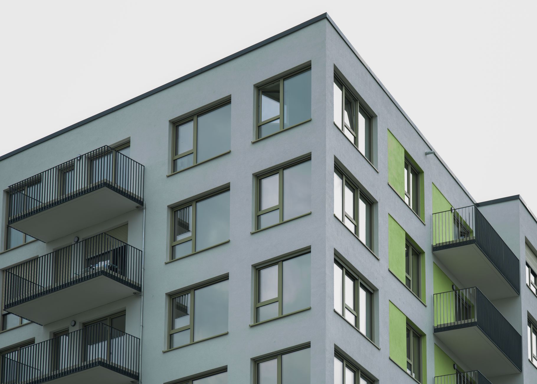 Contemporary architecture of a modern apartment complex with visible balconies and colorful accents.