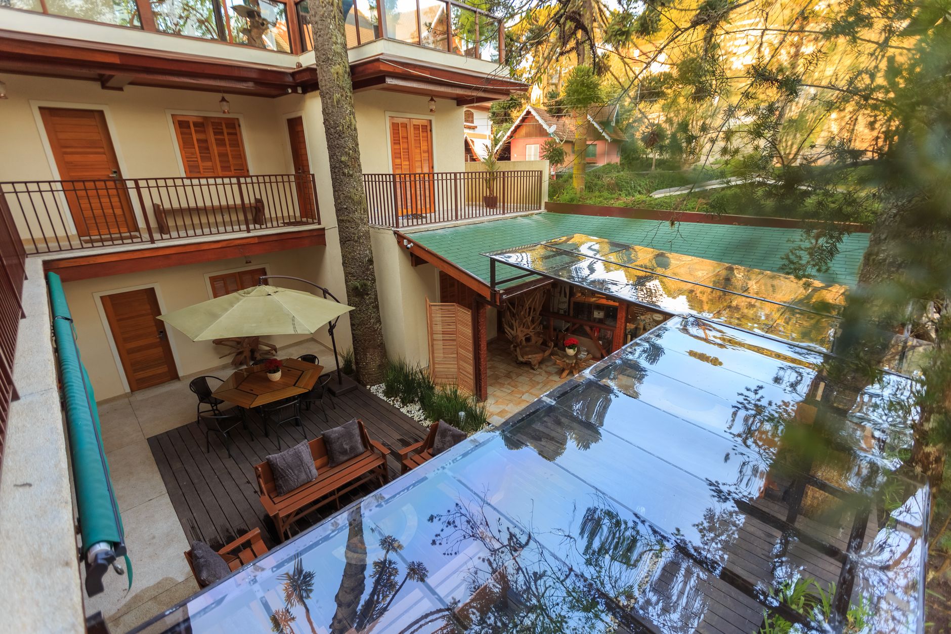 Outdoor courtyard with wooden doors, patio furniture, and glass canopy roof creates a serene atmosphere.