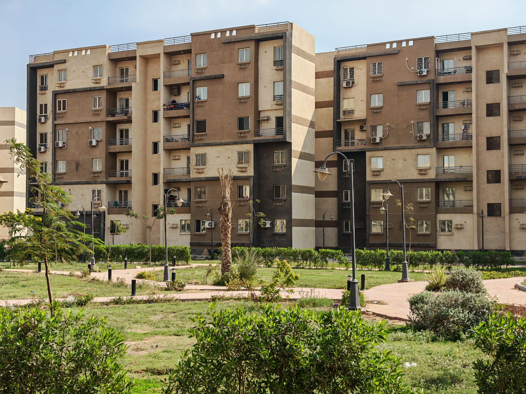 Exterior view of residential apartments with a landscaped garden area.