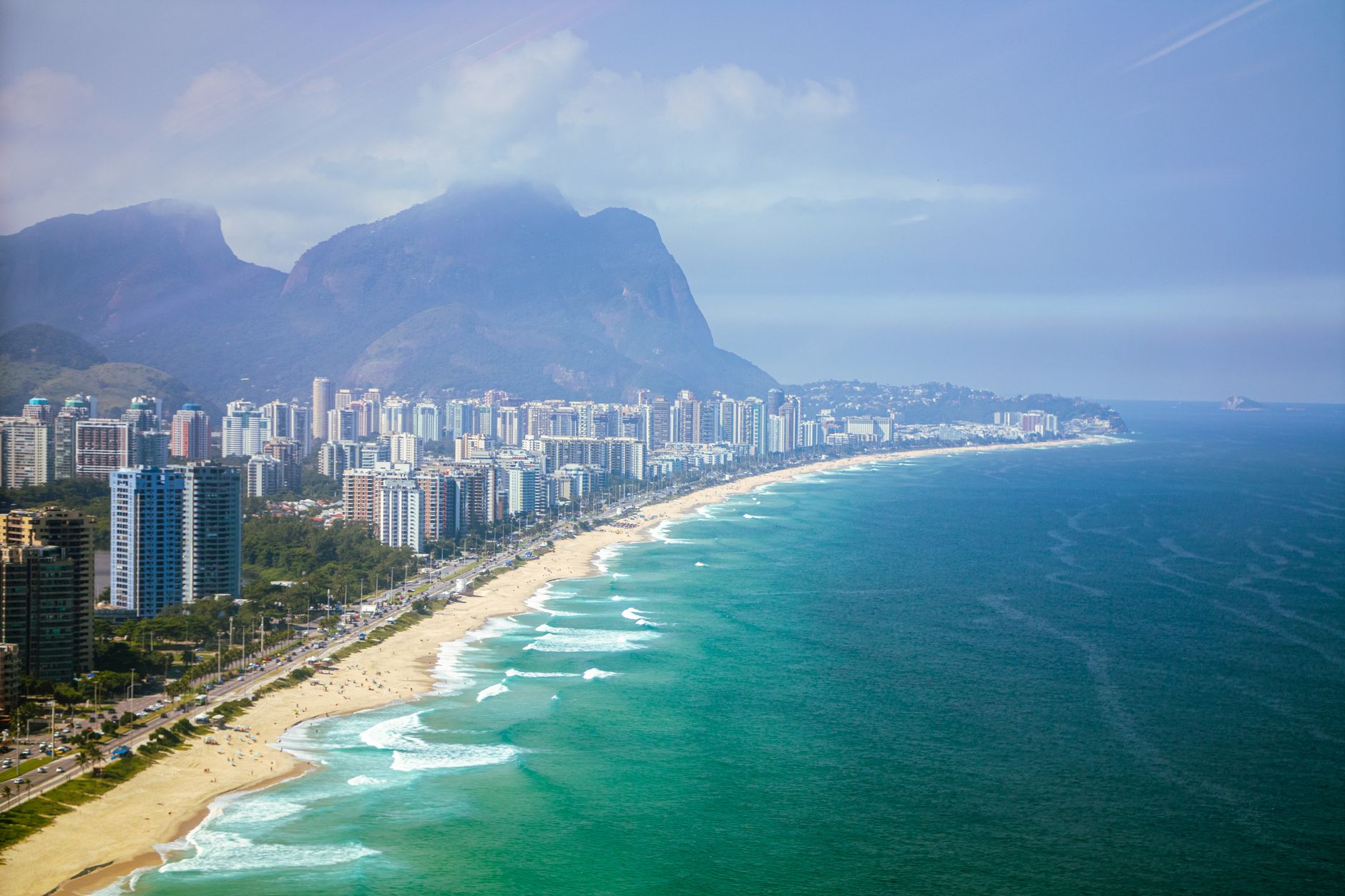 Stunning aerial view of Barra da Tijuca beach with city's skyline and mountains in Rio de Janeiro, Brazil.
