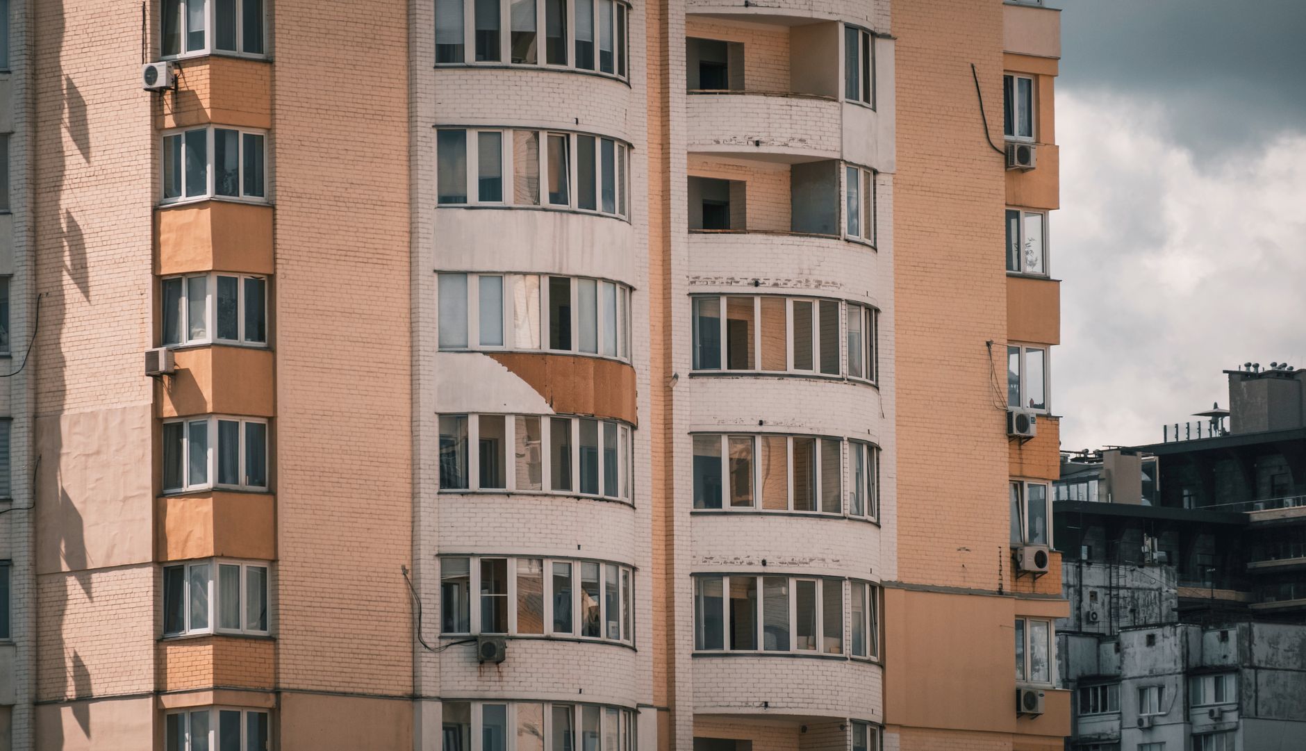 Close-up of a modern apartment building exterior featuring multiple balconies and windows.
